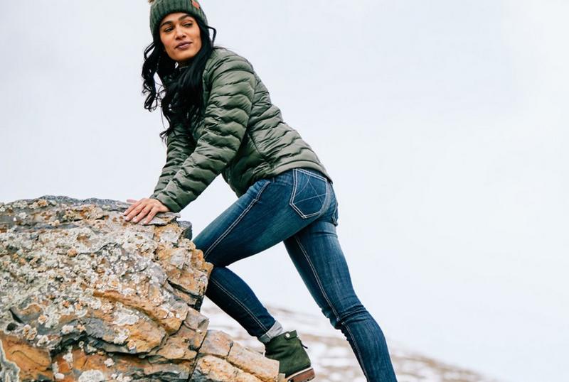 Woman climbing rock in Ariat Clothing