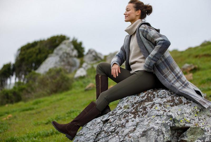 Woman sitting on rock in Ariat Countryside Collection