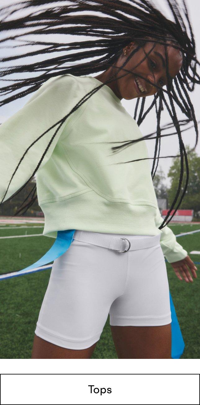 A Girl with long hair dancing on a field after playing flag football