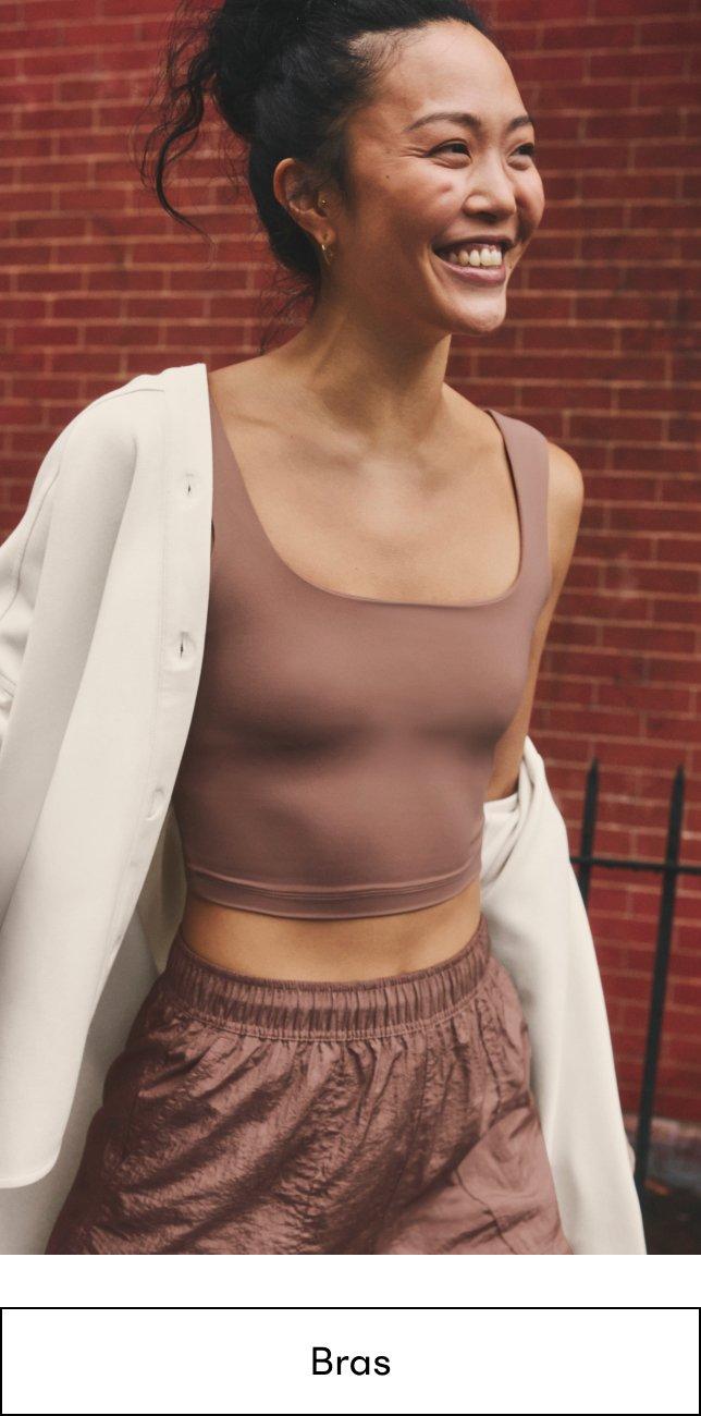 a woman in a brown top and brown pants smiling
