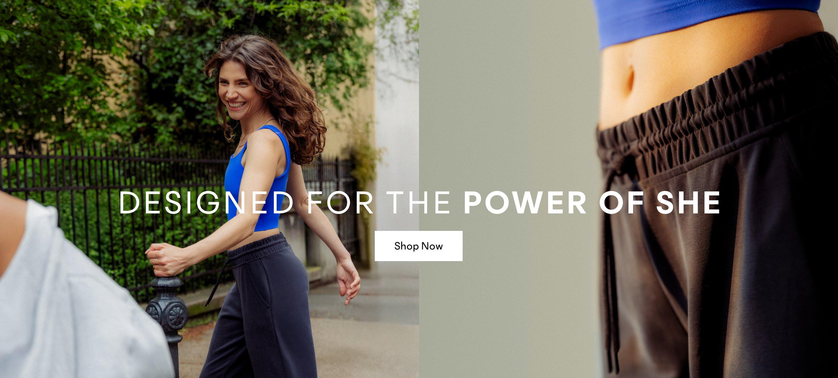 a woman in a blue top walking down a street. Designed for the Power of She. Shop Now