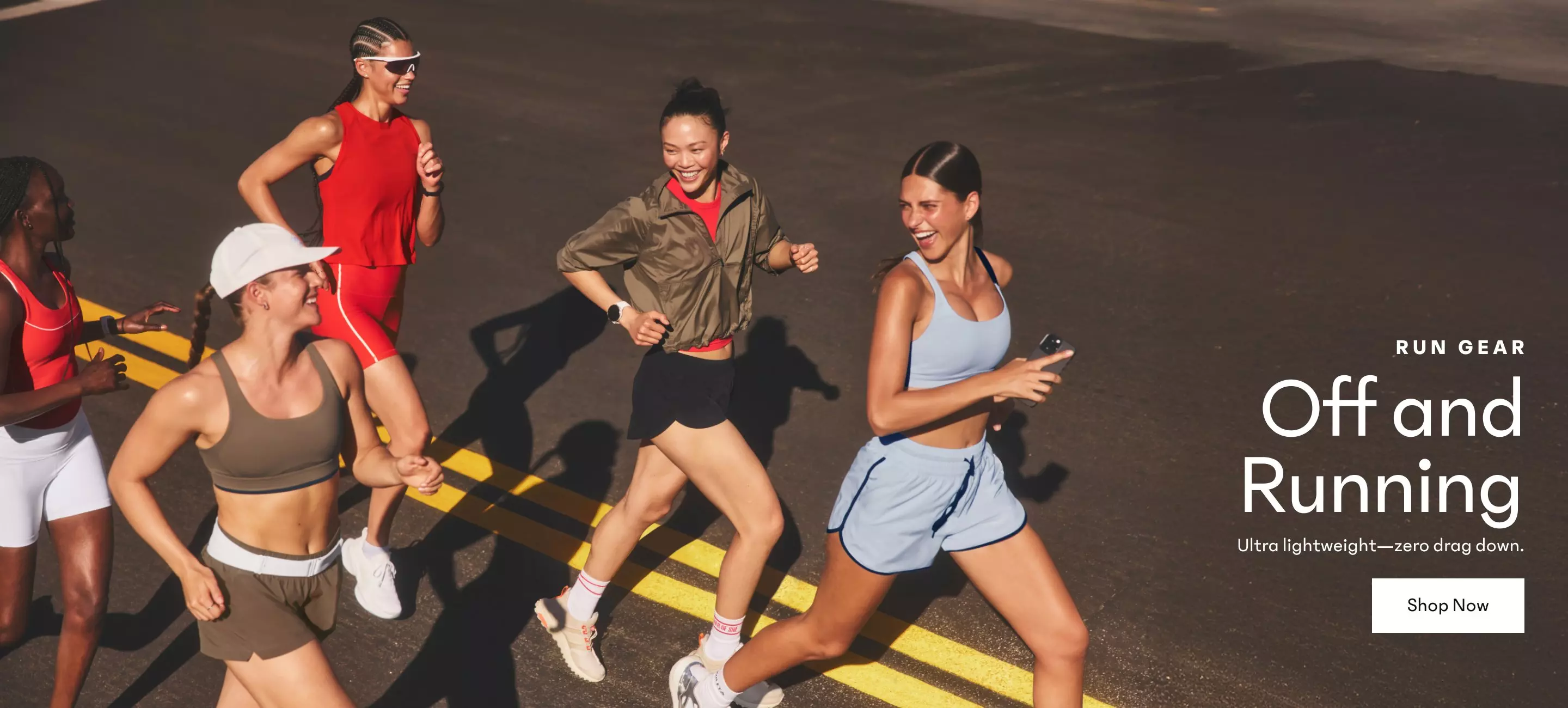 Women running in the street smiling. Shop Run Gear.