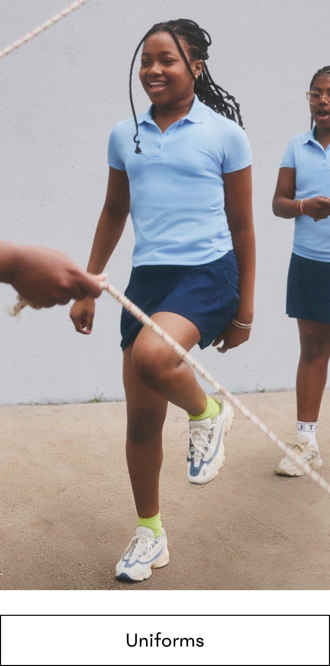 a girl smiling jumping rope in a uniform. shop girl uniforms.