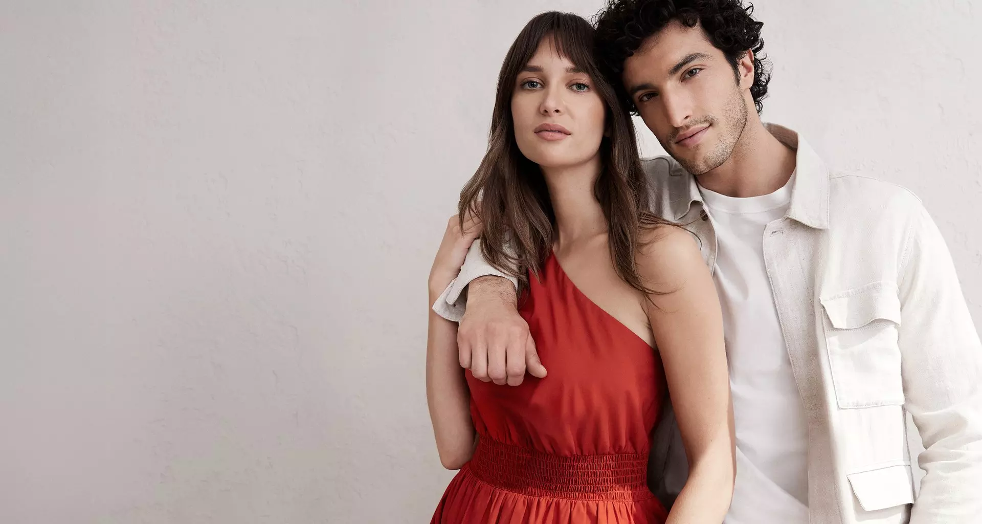 Woman in orange dress. Man in a white jacket.