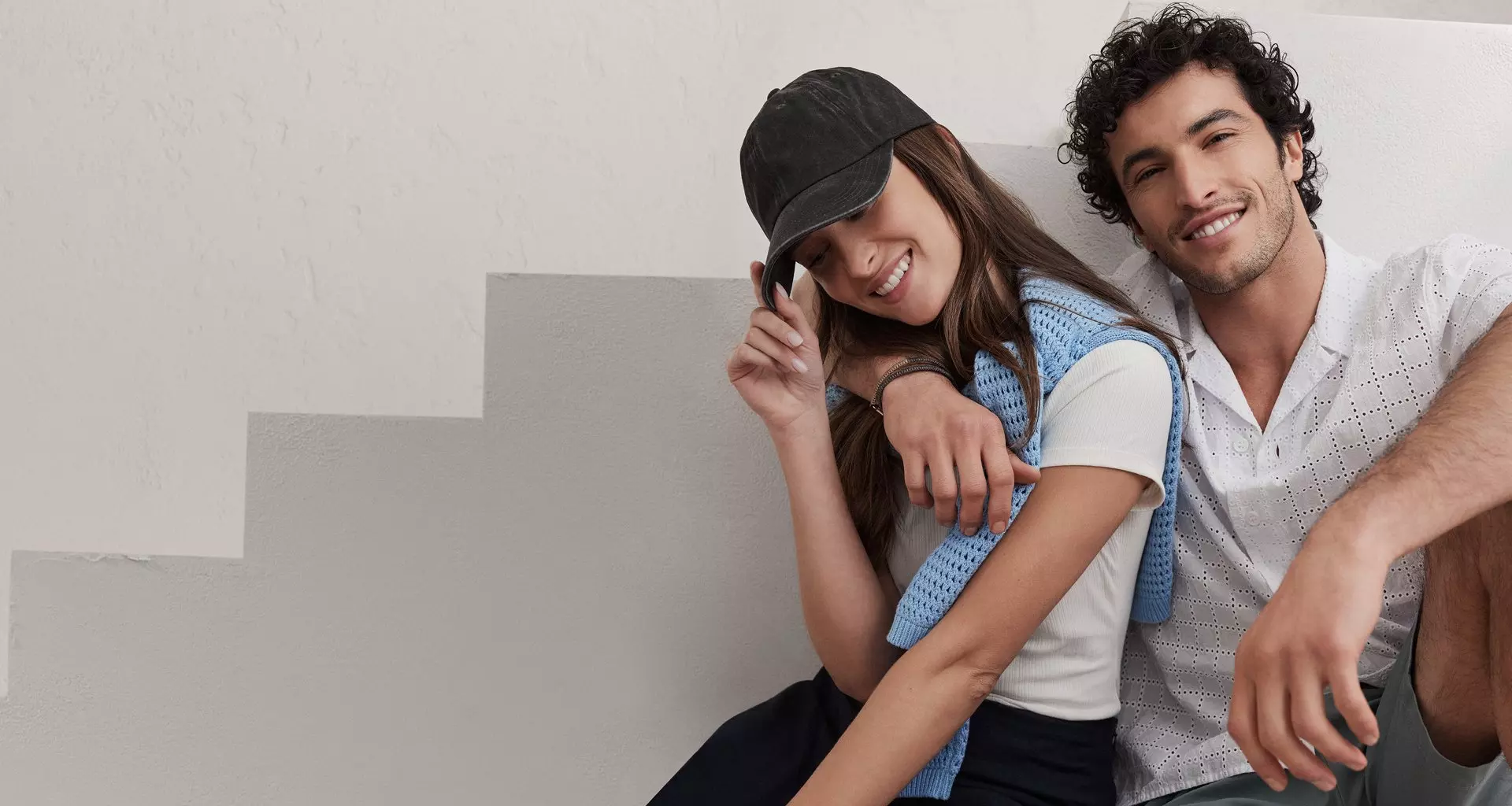 Woman in baseball hat. Man in white polo. 