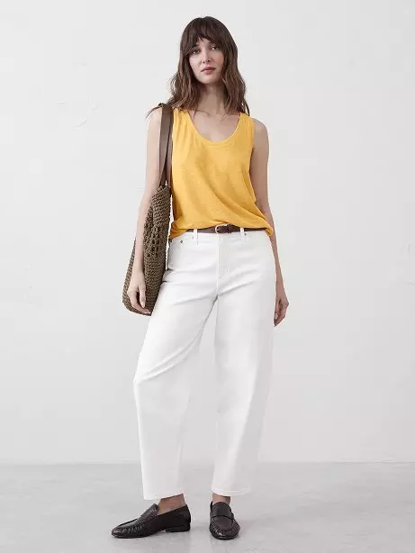 Woman in yellow tank top and white pants.