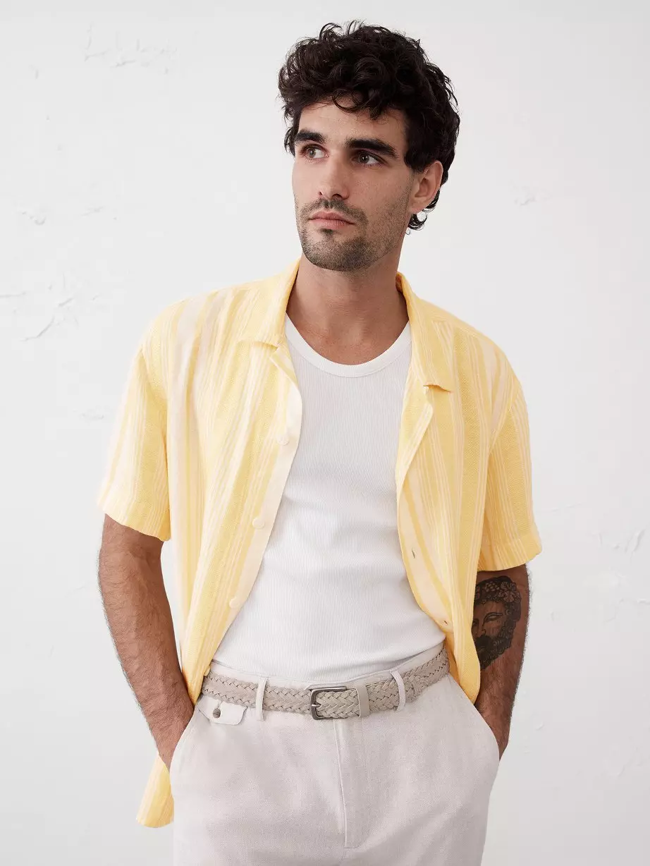Man in yellow shirt and off white pants.