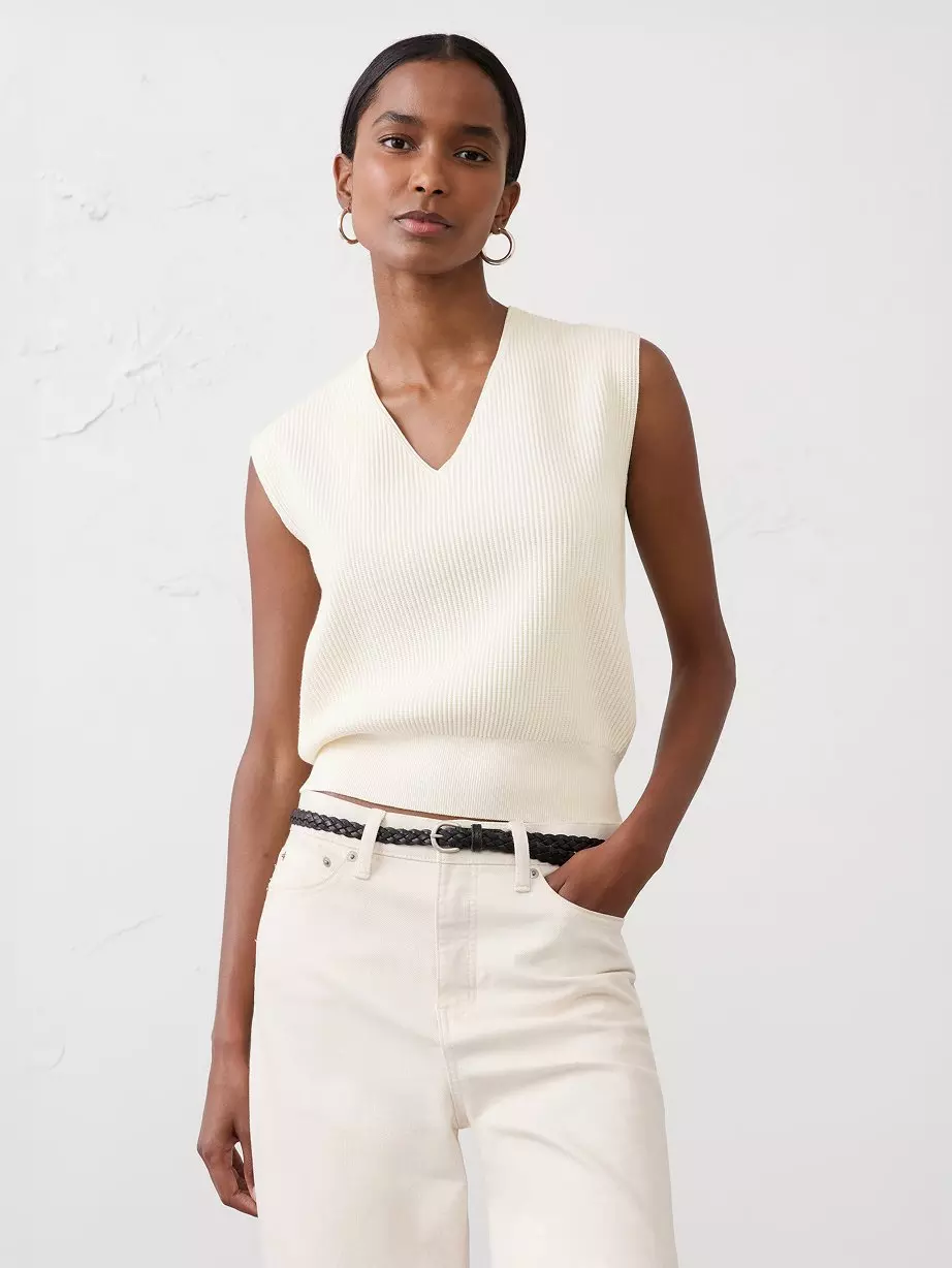 Woman in white sweater vest.