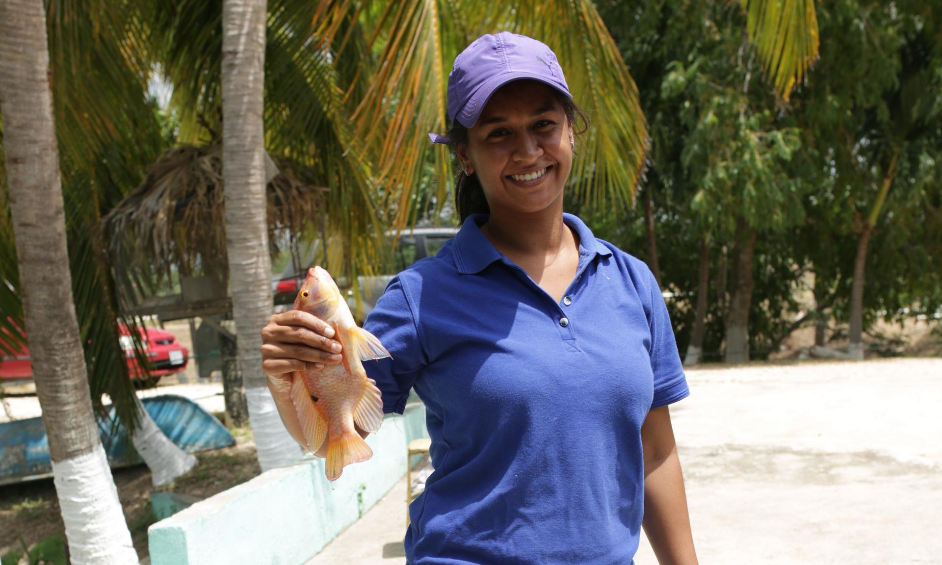 Woman holding a fish and smiling