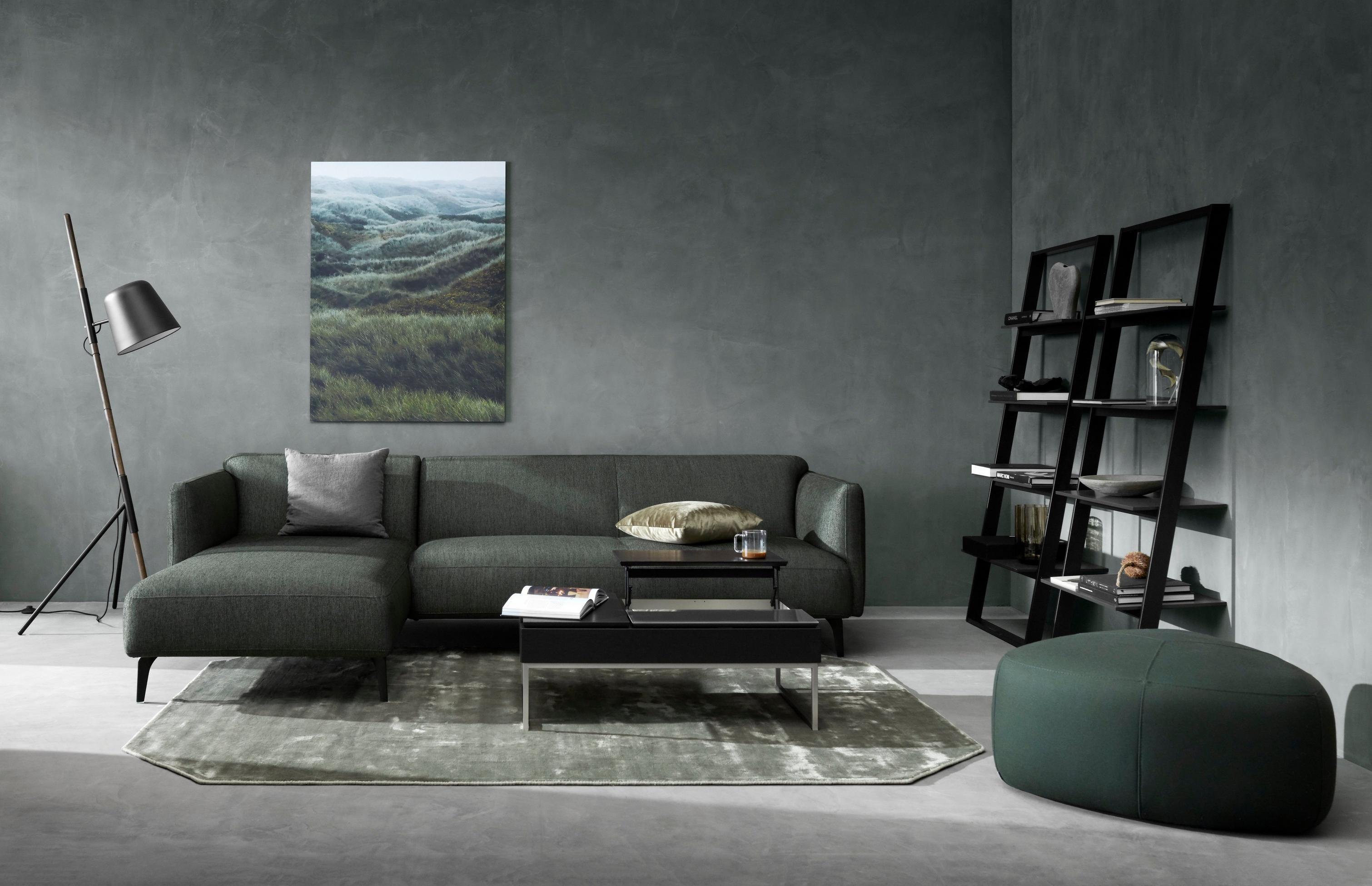 Modena sofa with resting unit in dark green Bristol with the Bordeaux wall system.