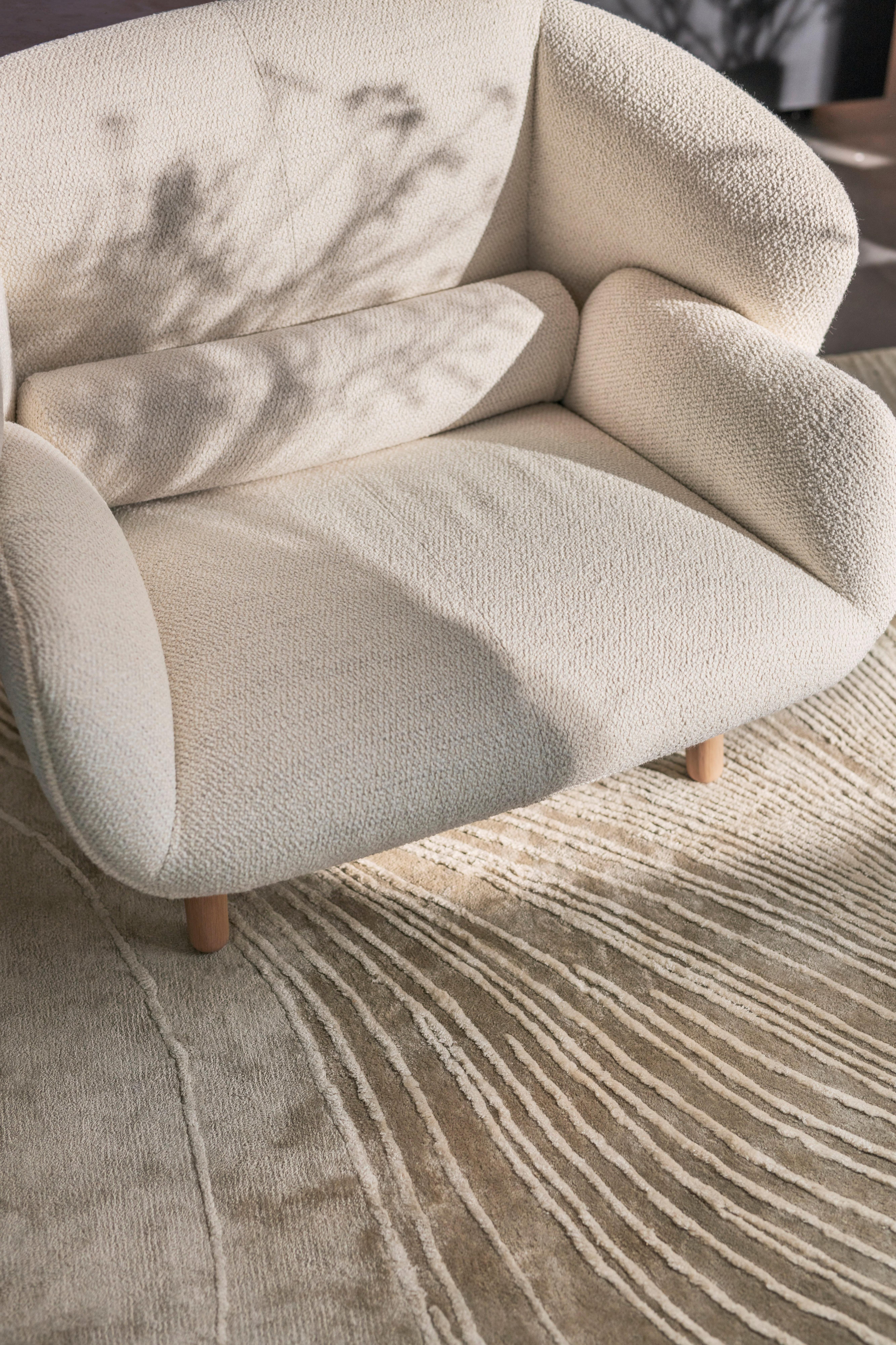 Butaca Fusion en tela Lazio blanca combinada con la alfombra Tide en gris y blanco.