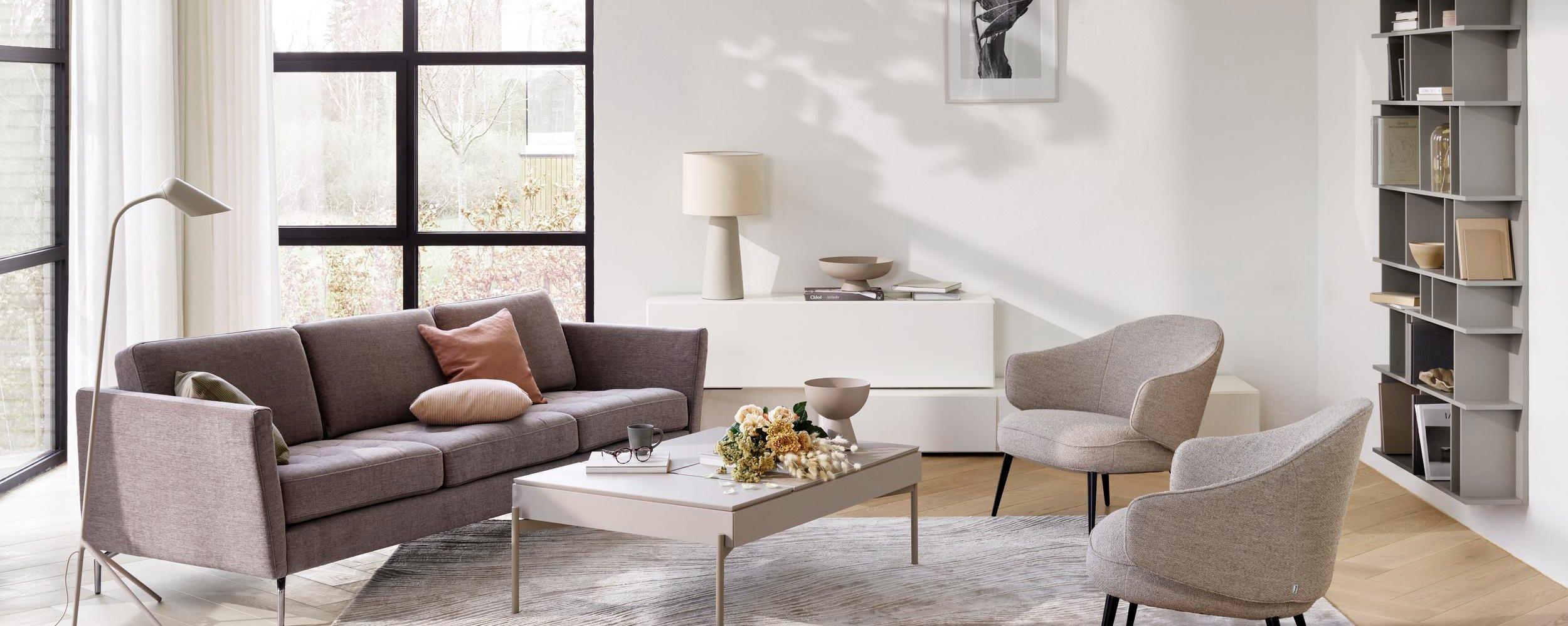 Καναπές Osaka με καπιτονέ καθίσματα σε γκρι ύφασμα Tomelilla και τραπέζι σαλονιού Chiva με αποθηκευτικό χώρο.