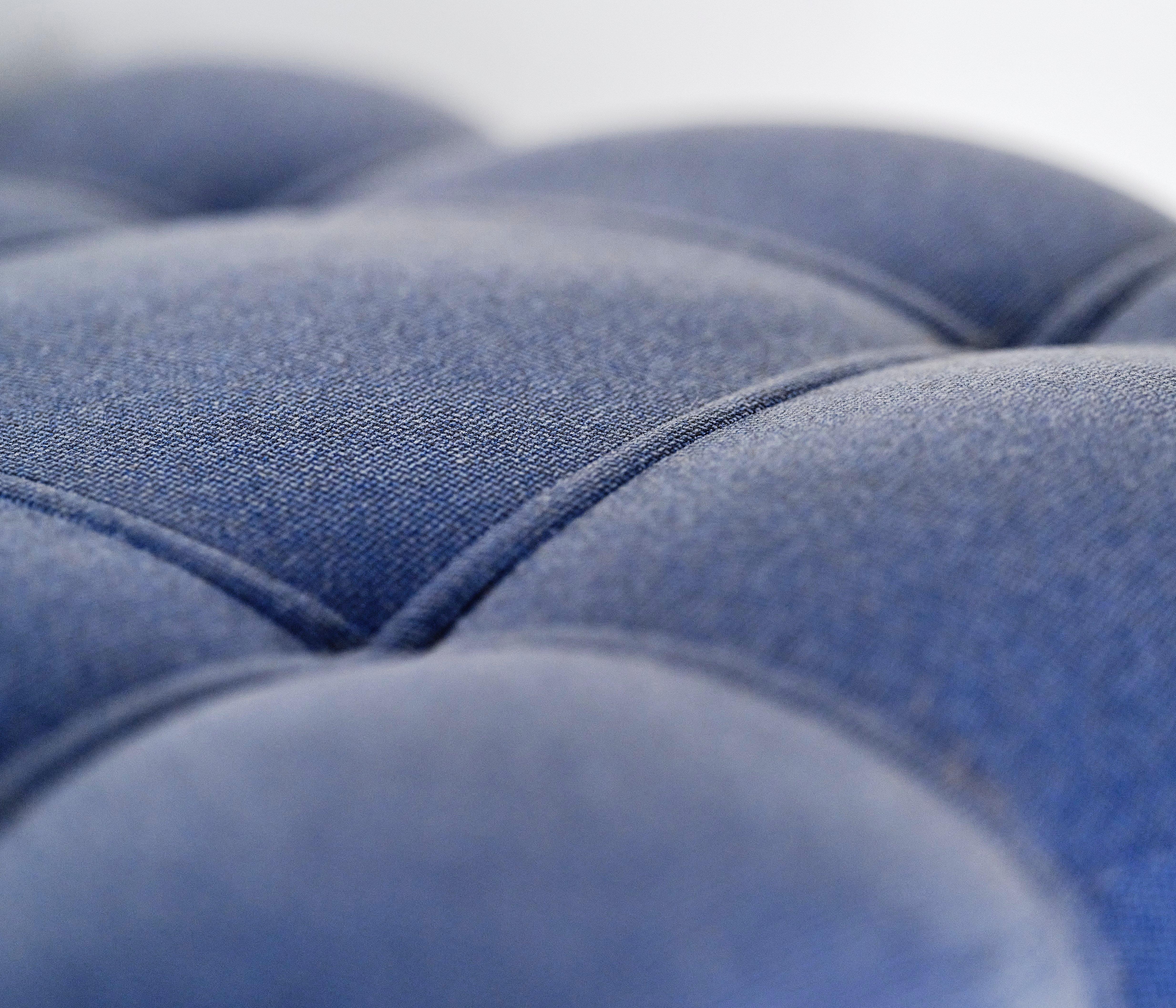 Lähikuva sinisestä napitetusta kankaasta.