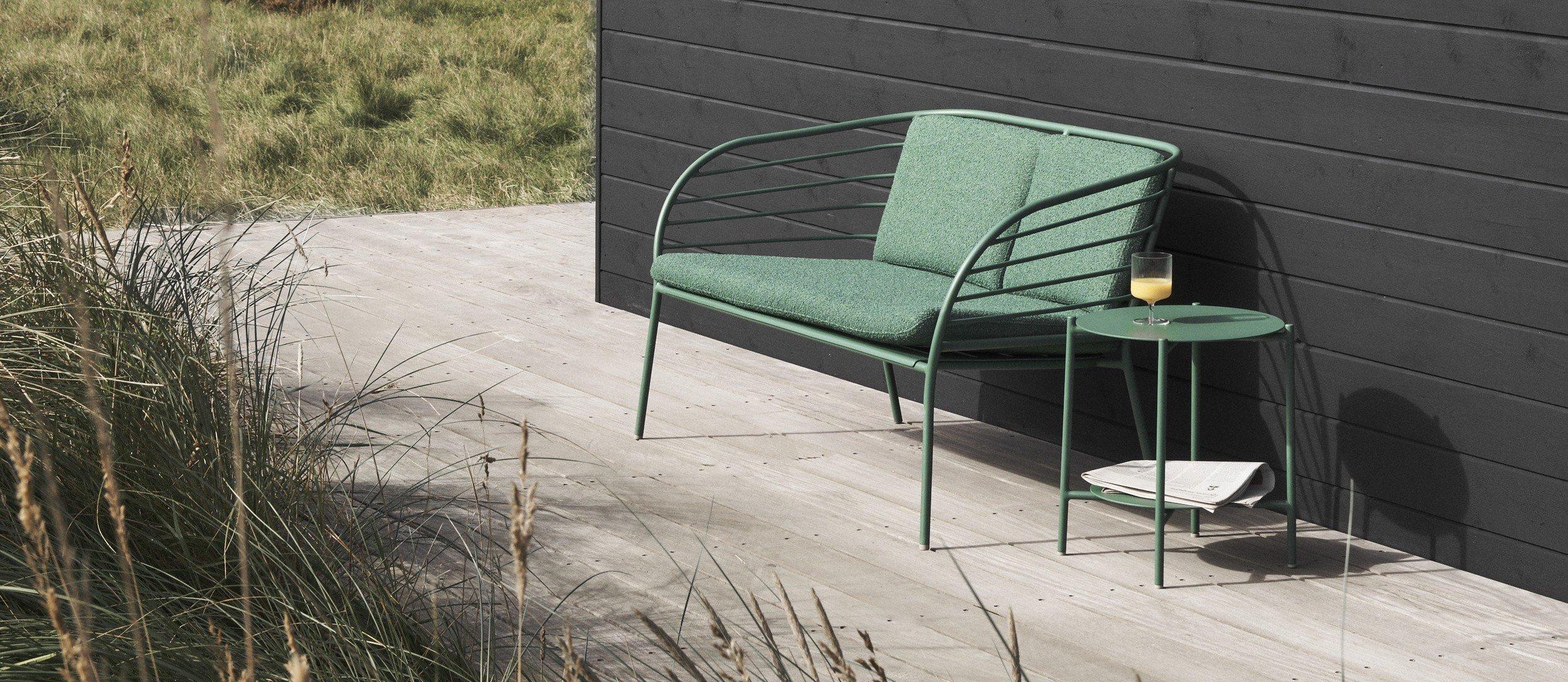 Verandaen til et dansk sommerhus møbleret med Cancún loungesofa og sidebord i mat grøn.