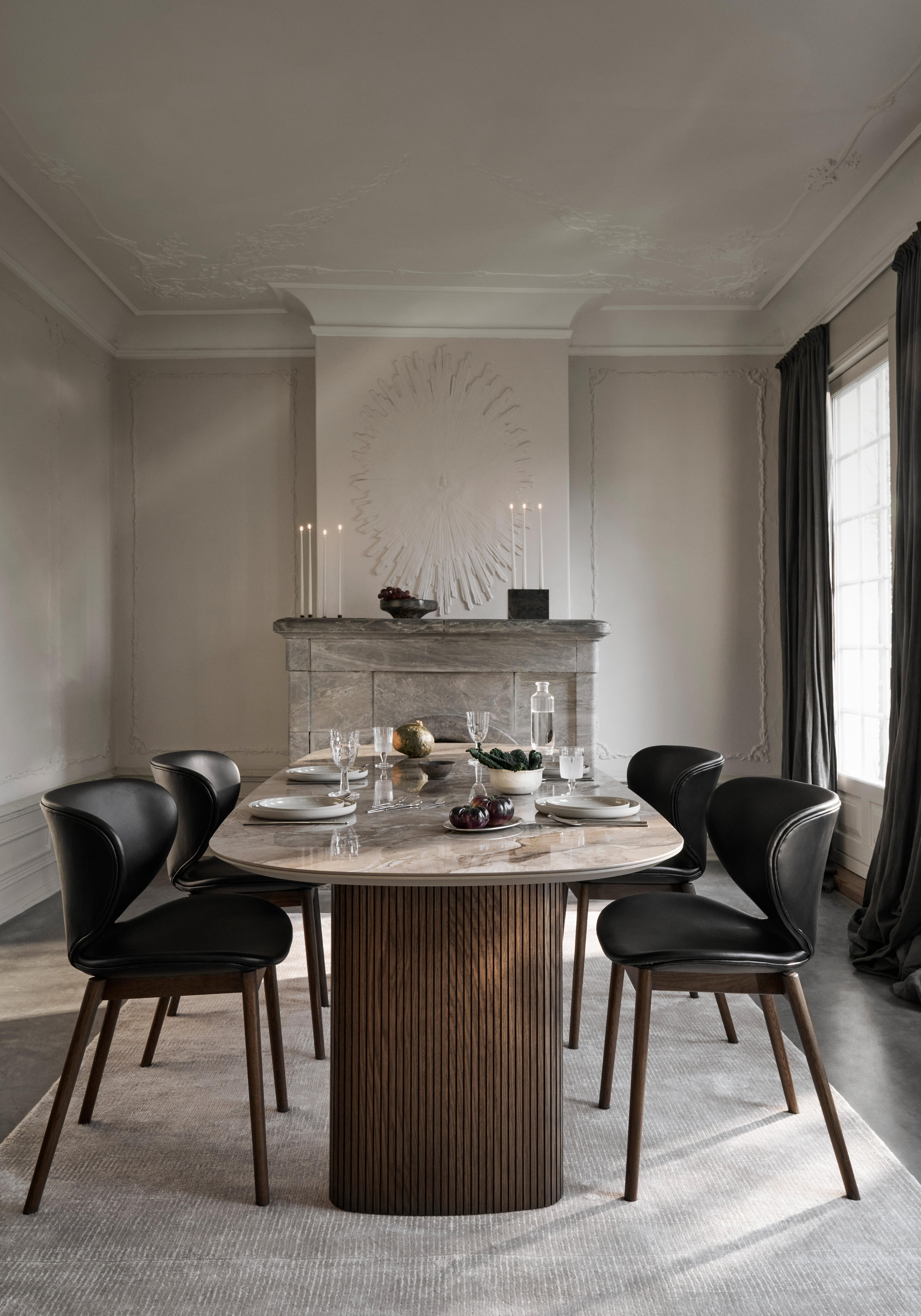 Stůl s knihami, koženými deskami a otevřenou zásuvkou s časopisy.