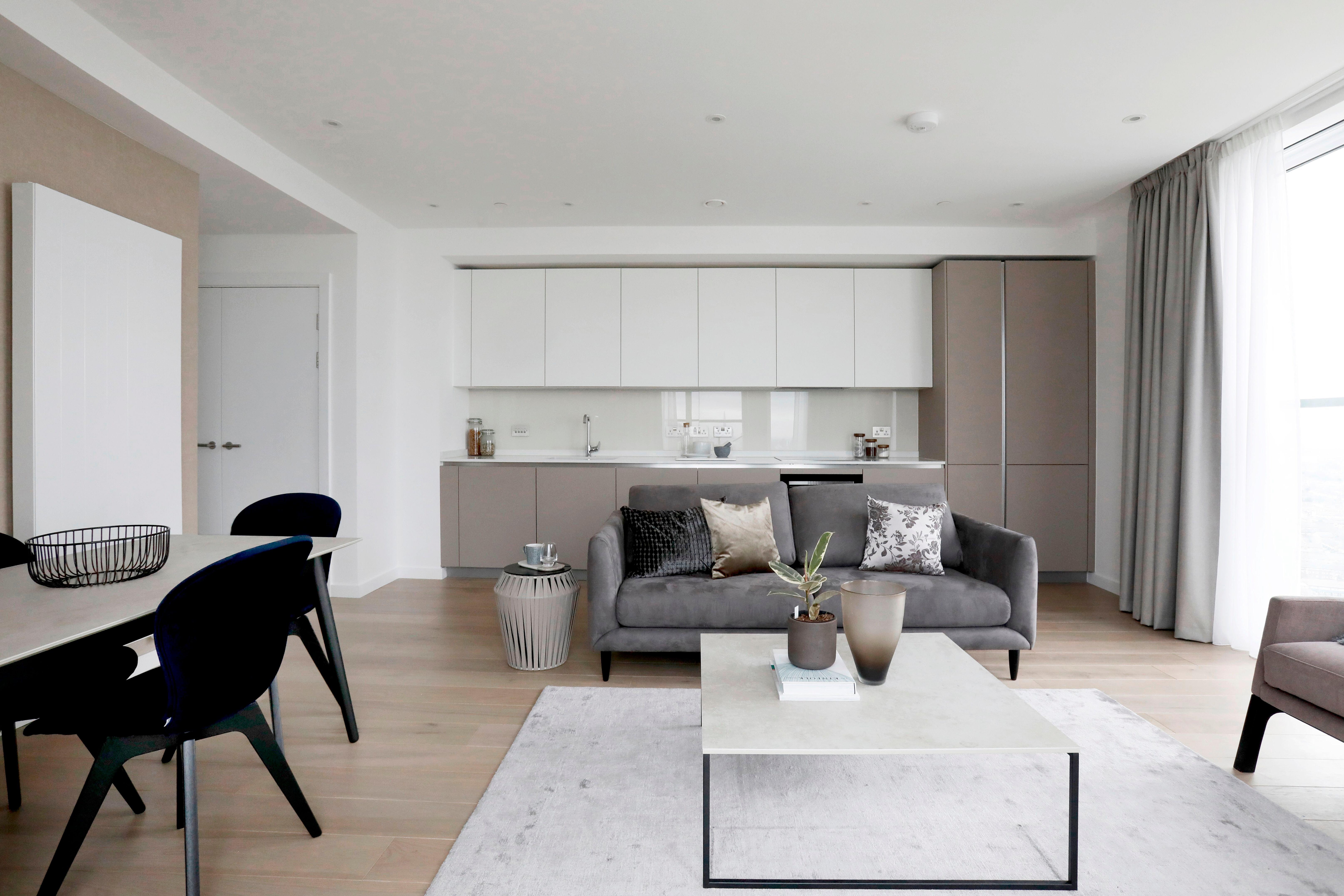 Modern living space with kitchen, dining, and seating areas in neutral tones.