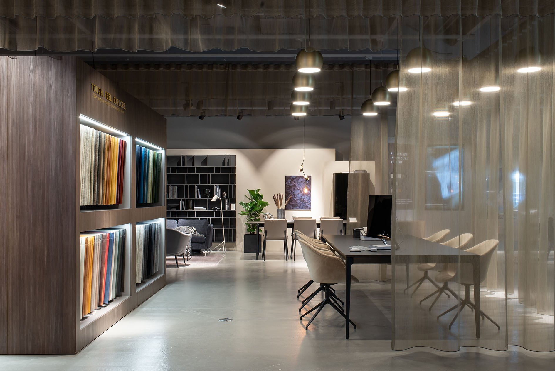 BoConcept store interior featuring furniture displays and fabric samples under warm lighting.