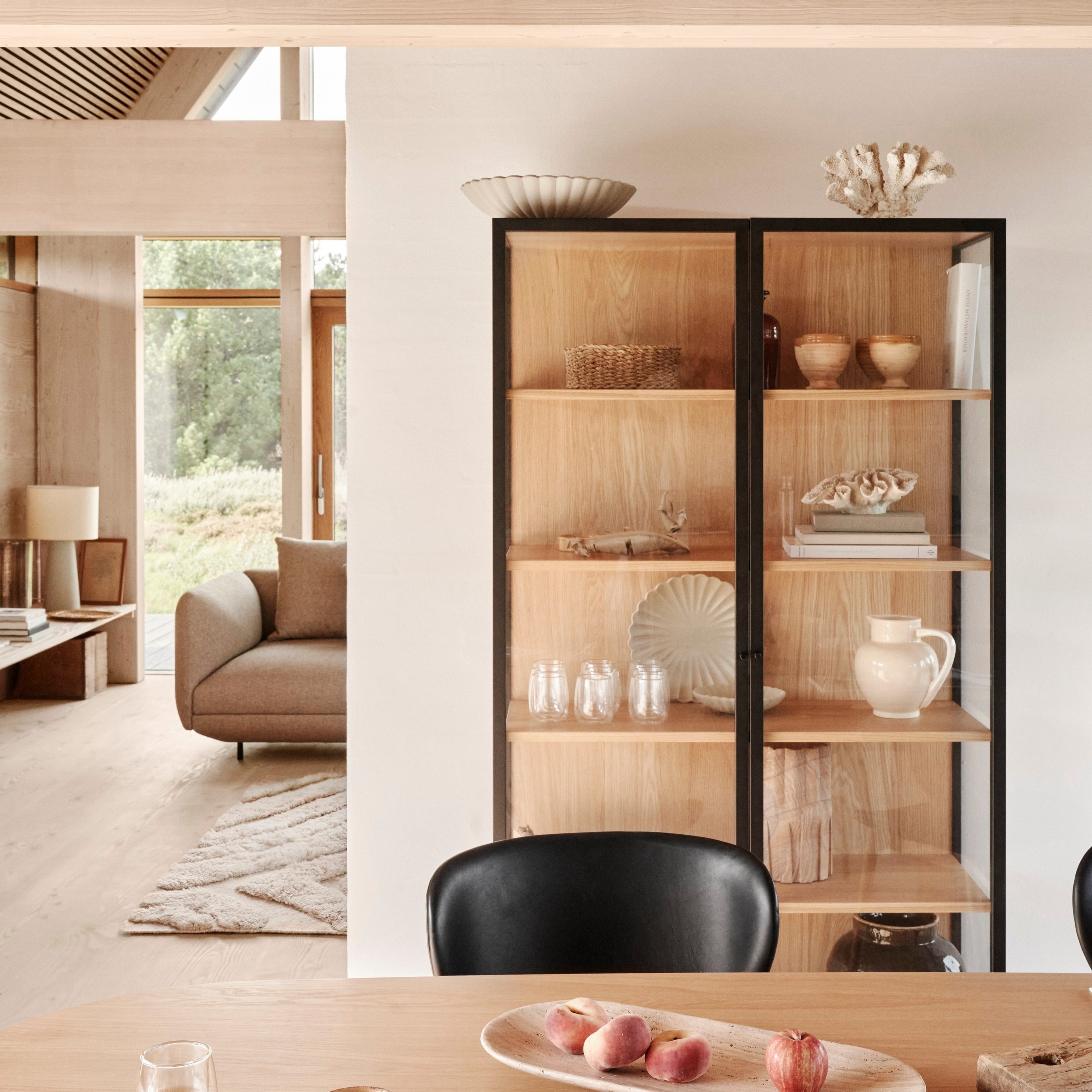 Inviting Scandinavian dining space featuring the Lund glass cabinet in Natural Oak.