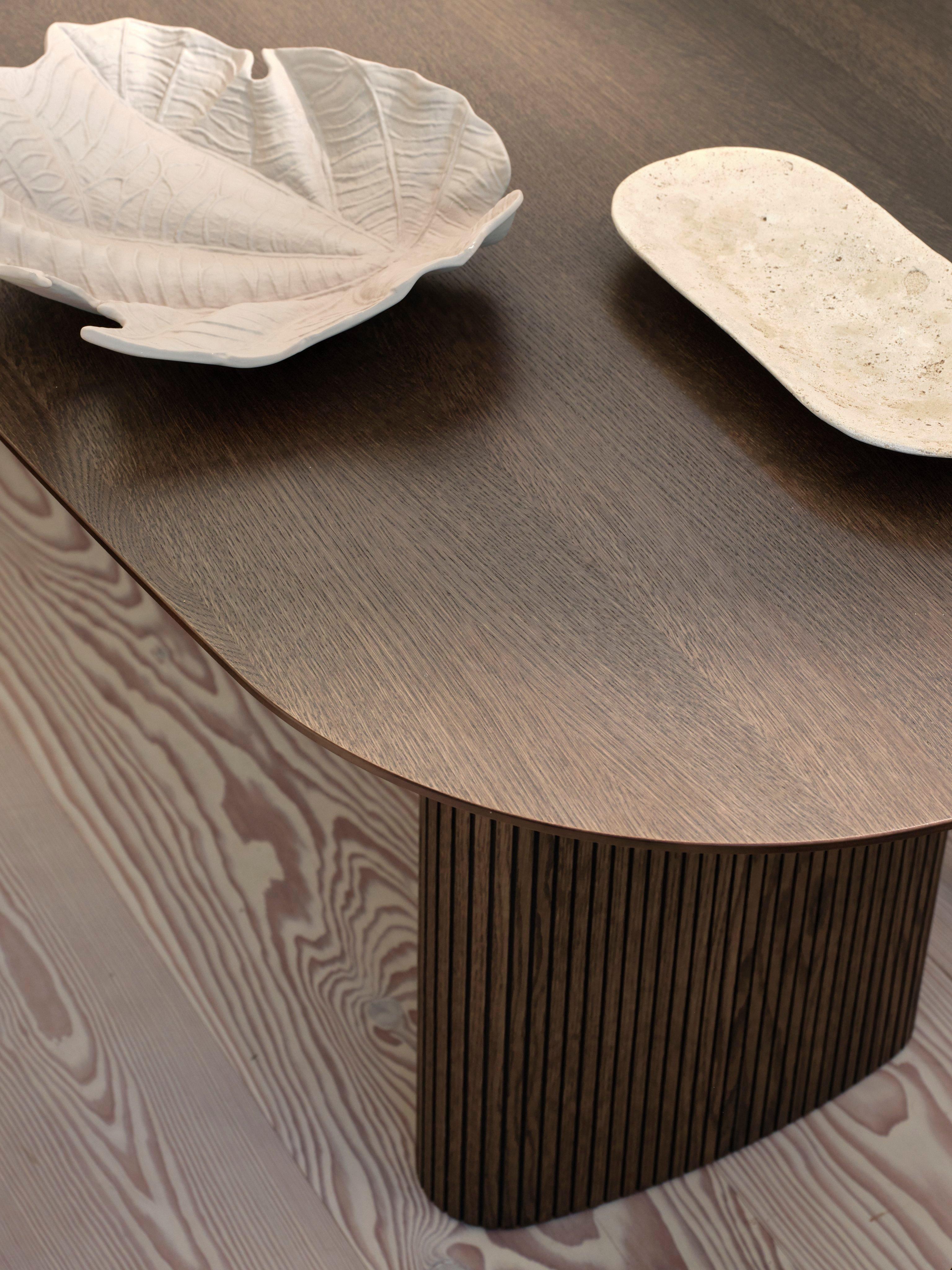 Wooden table with two decorative white dishes on top.