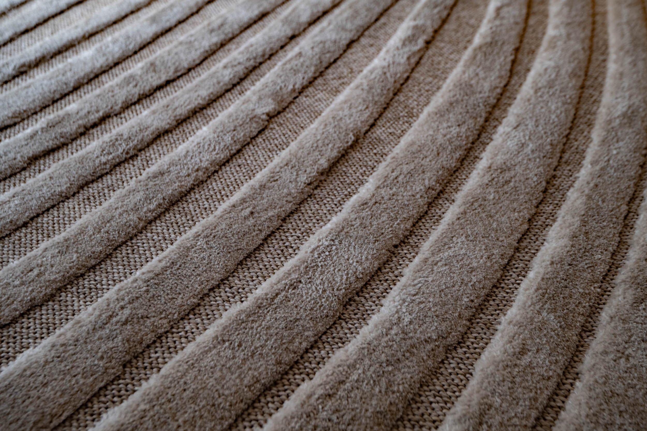 Gros plan d’un tapis texturé à rayures en relief.