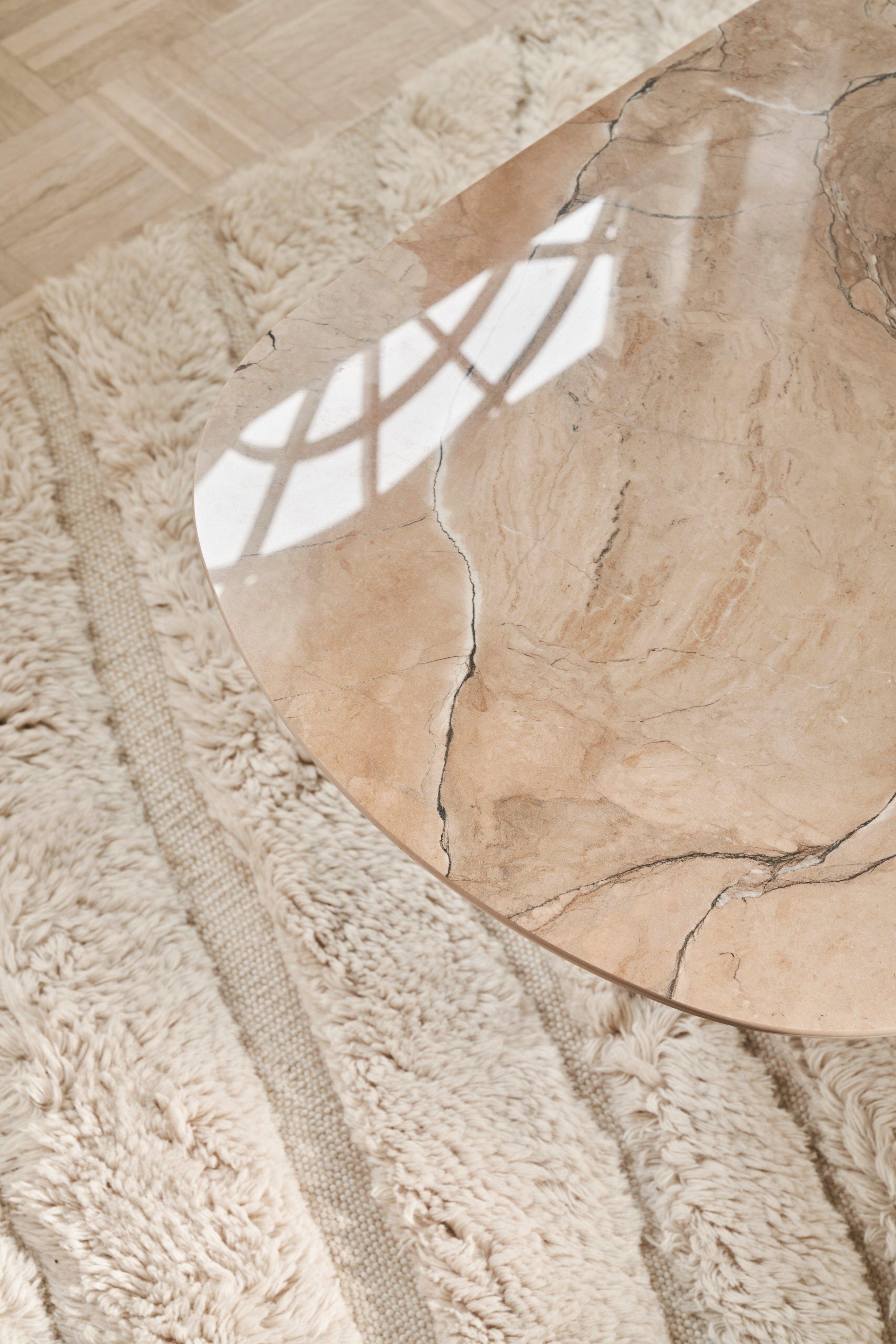 棕色陶瓷 Santiago 椭圆形咖啡桌搭配 Form 地毯。