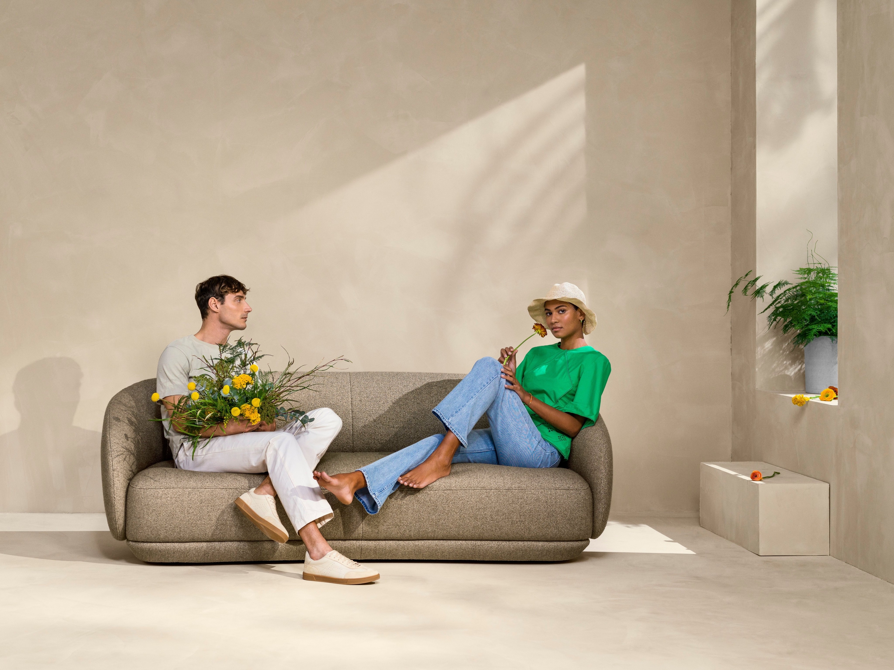 Par sitter på Bolzano sofa i brunt Lazio tekstil.