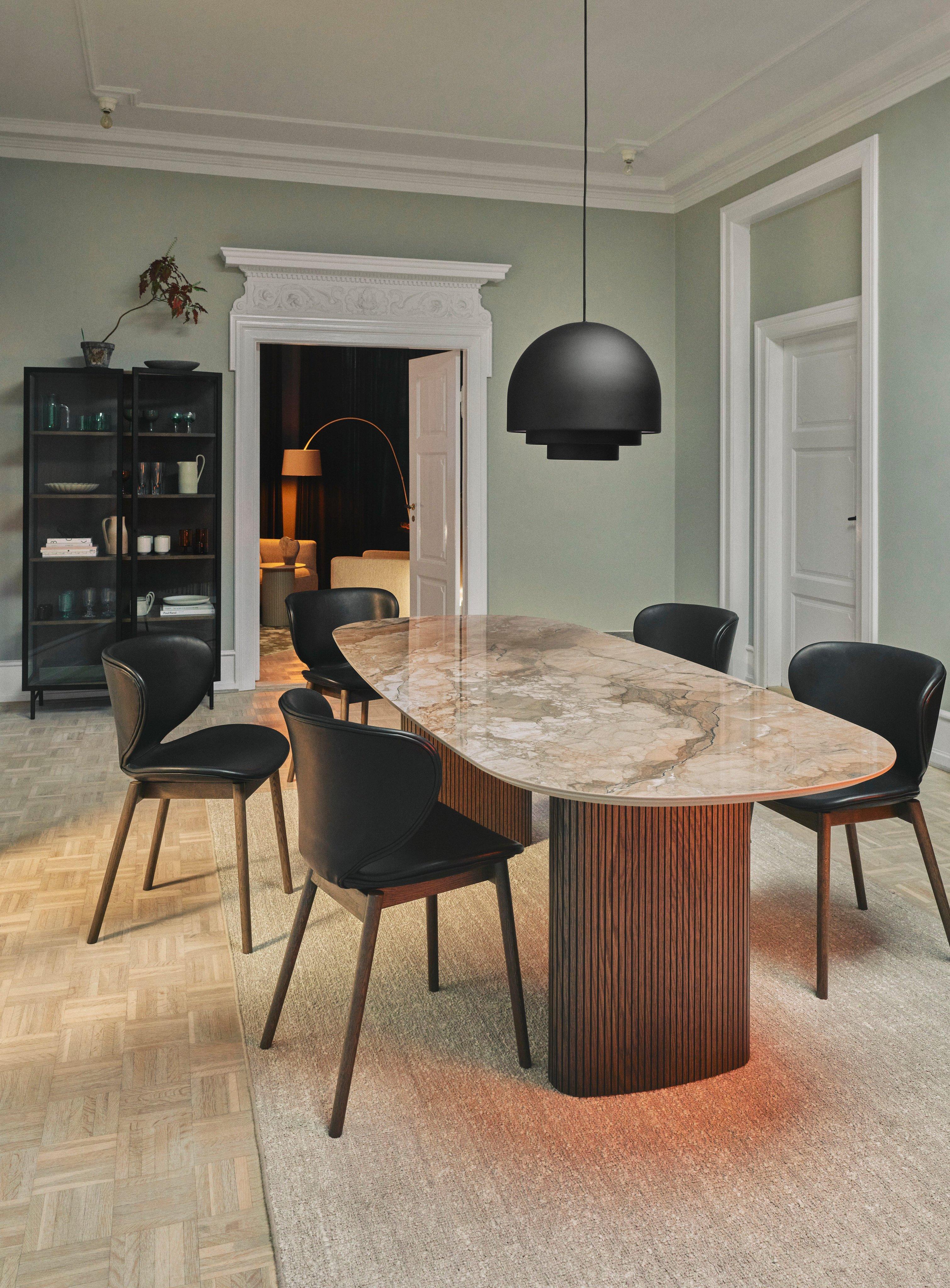 設計師用餐室採用 Santiago 餐桌和黑色 Sienna 皮革的 Hamilton 餐椅。