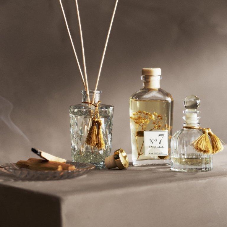 リードディフューザーと香水ボトル、煙を上げる香。