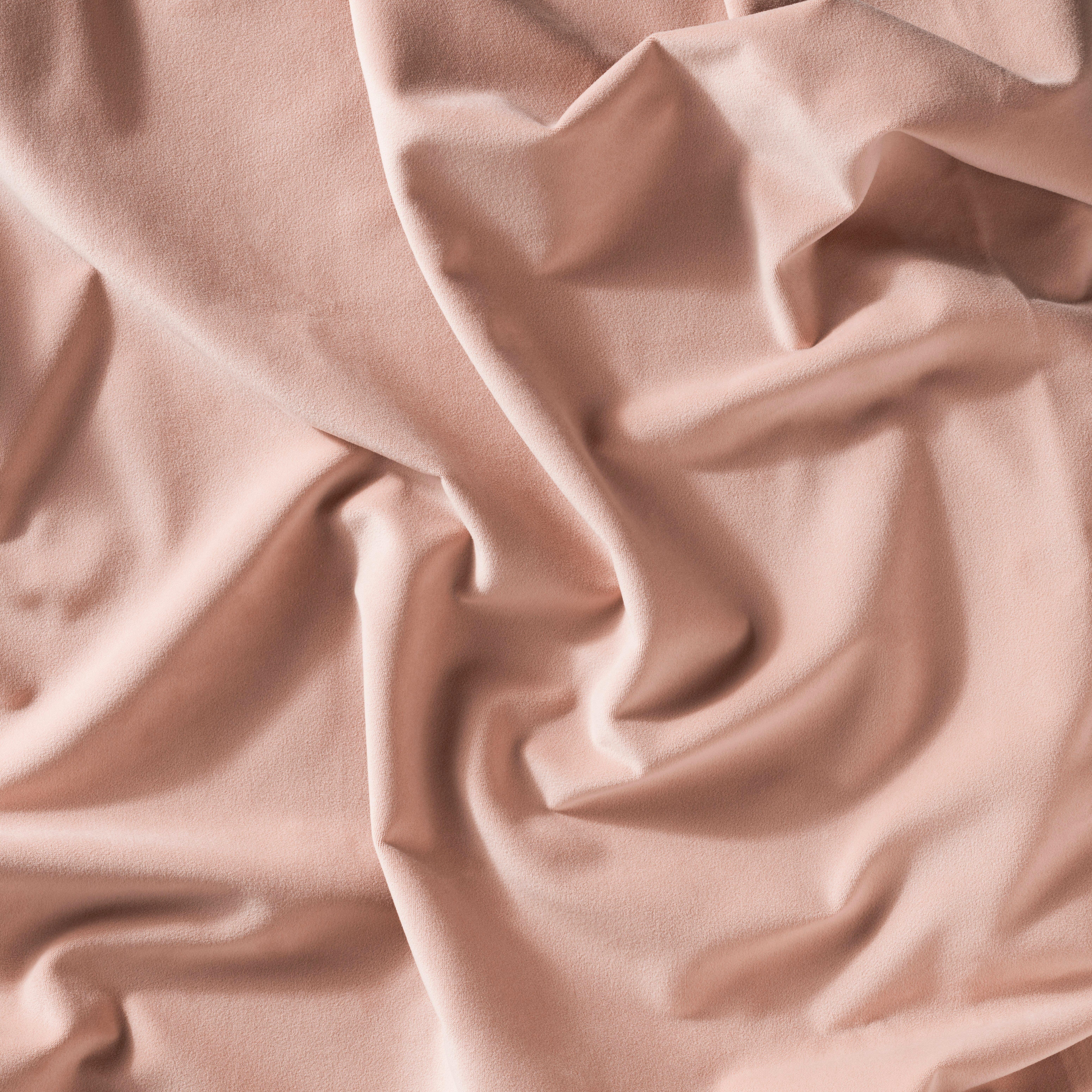 Soft pink fabric with visible folds and texture.