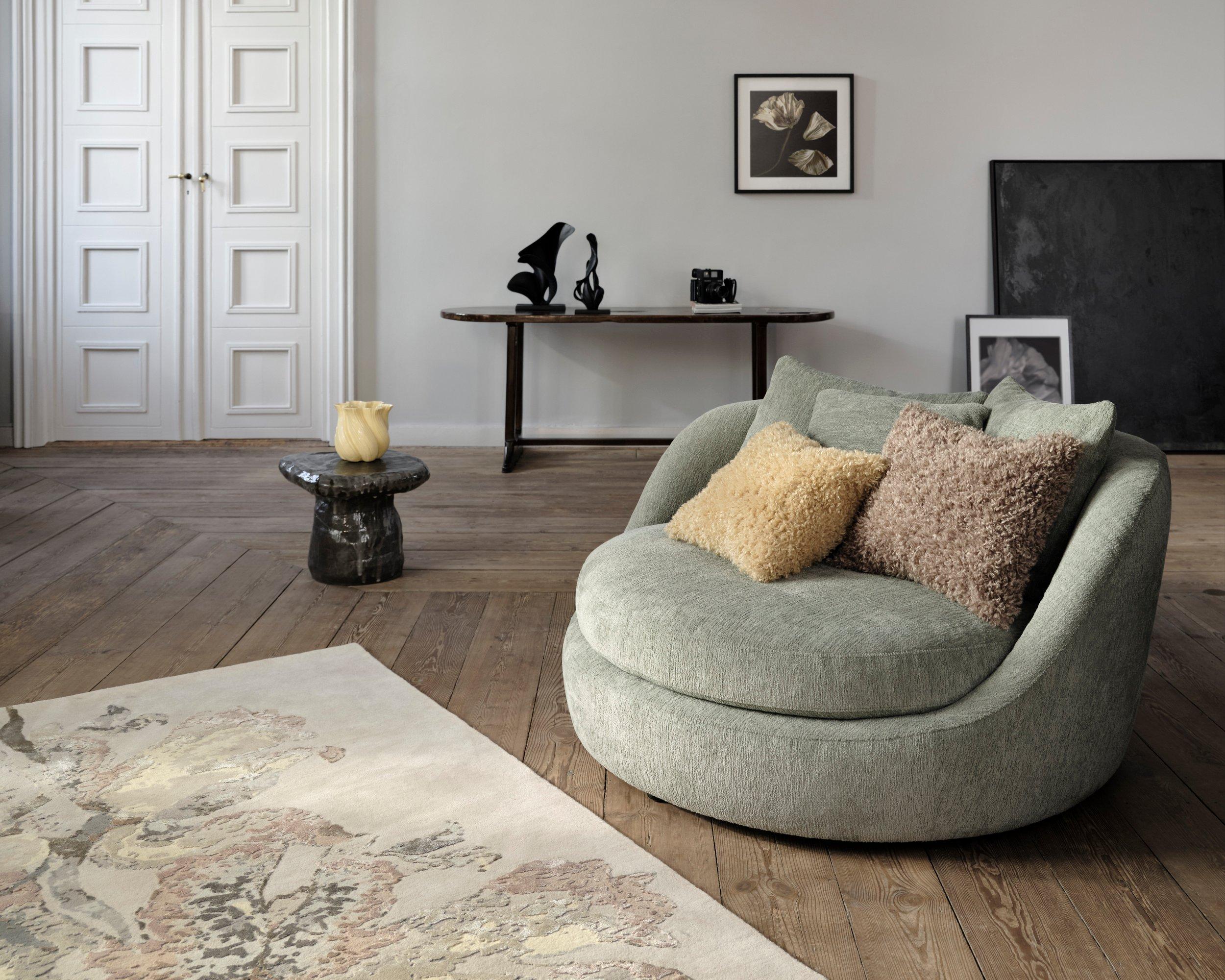 Interior with beige Flora 7 rug, black Flora 4 and Flora 5 sculptures, Flora 8 artwork, Flora 6 vase, and golden and latte Teddy cushions.