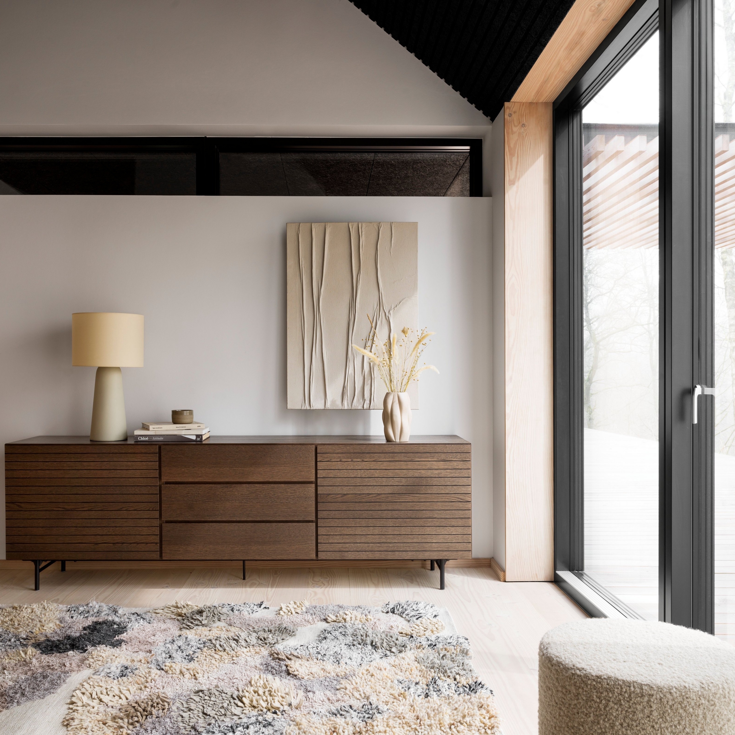 The Lugano sideboard in a dark oak veneer finish, placed against a wall.