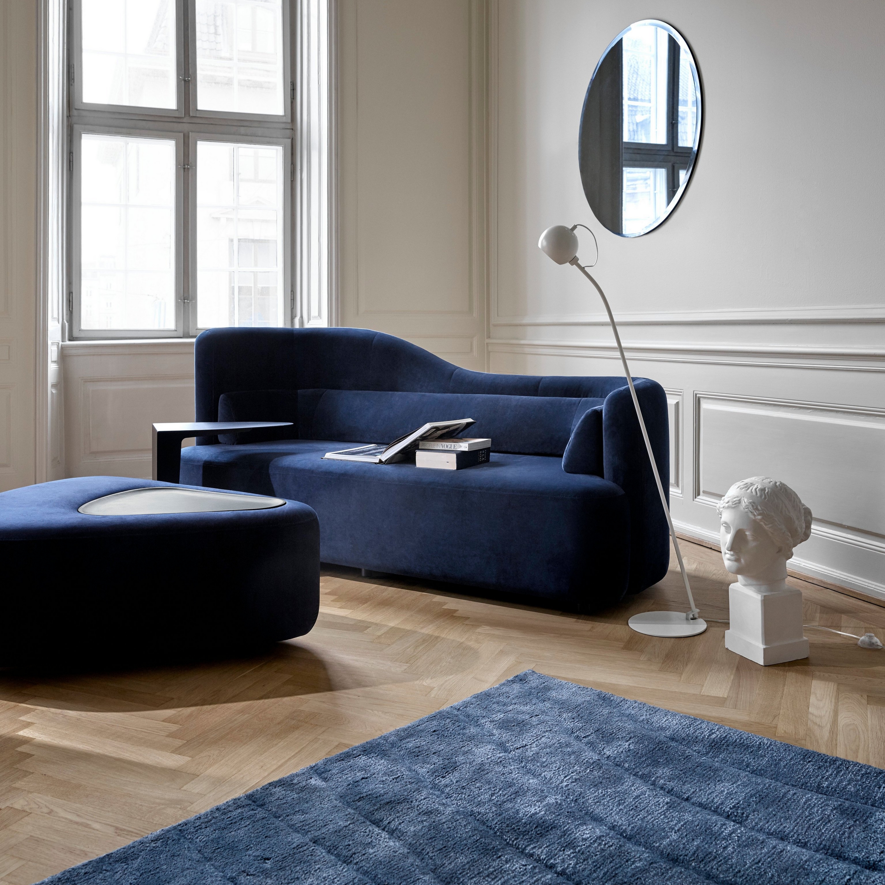 Wyrafinowana przestrzeń mieszkalna z sofą Ottawa oraz podnóżkiem Ottawa tapicerowanym niebieską tkaniną Velvet
