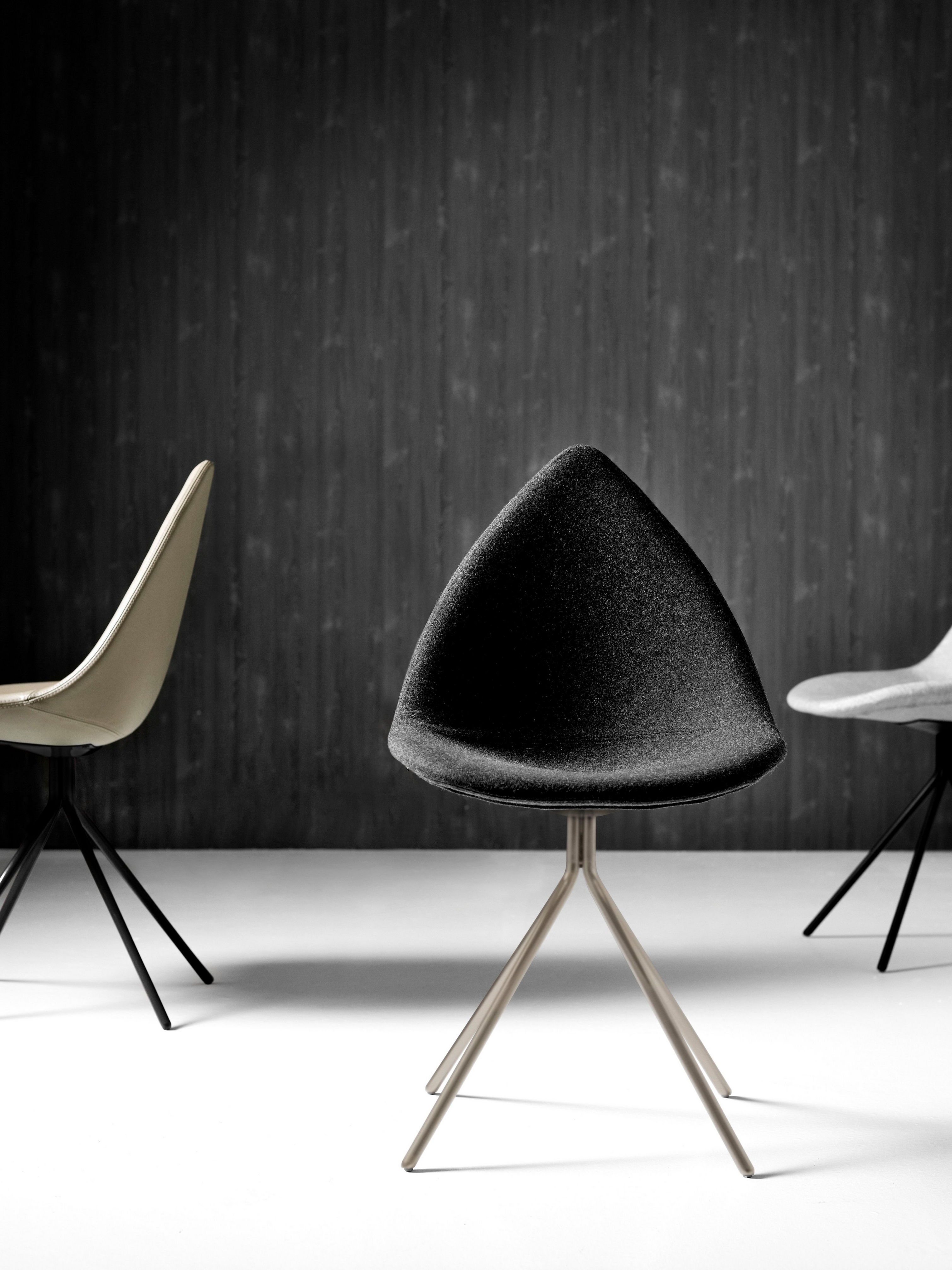 Moderna Ottawa-stolar i en monokrom miljö med en strukturerad svart bakgrund.