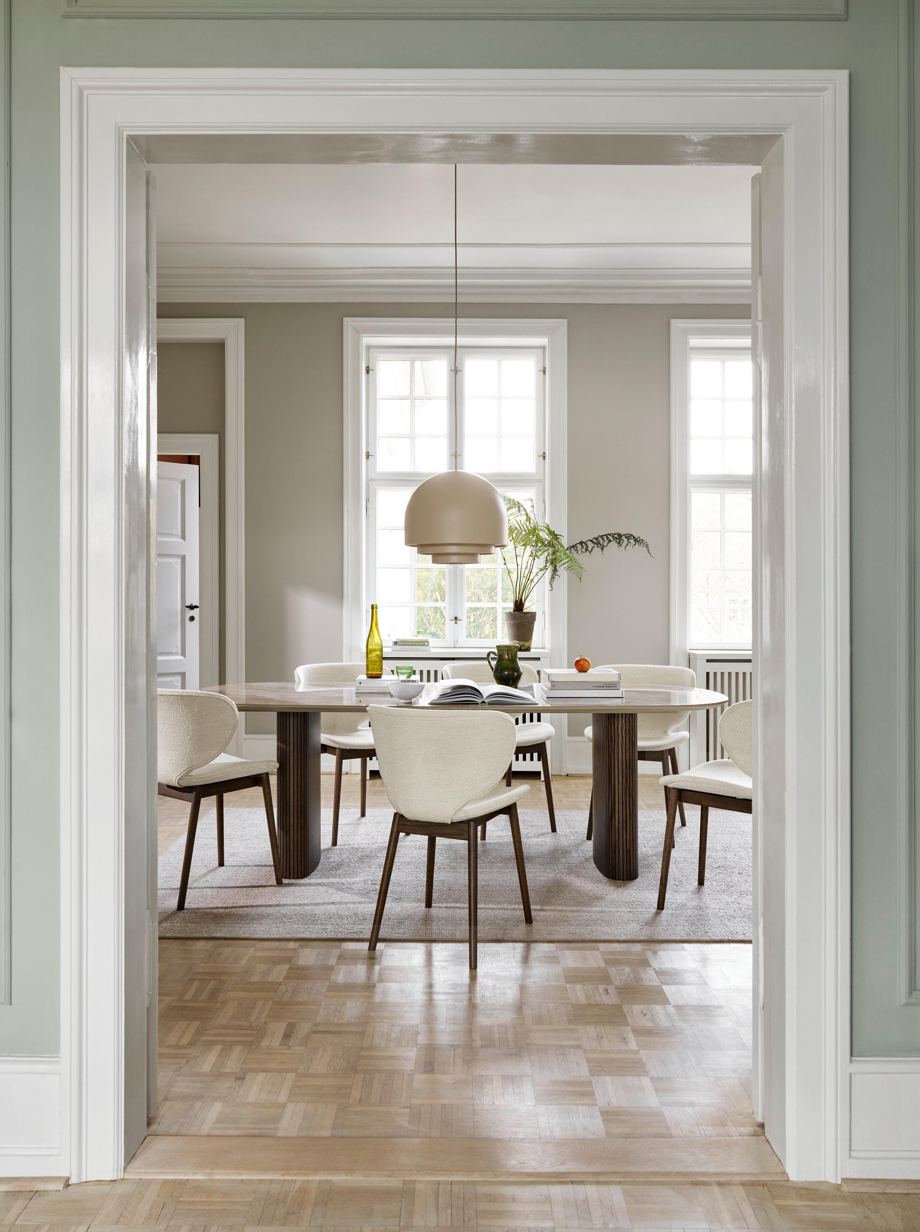 採用 Santiago 餐桌和白色 Lazio 布料 Hamilton 餐椅的寧靜用餐空間。
