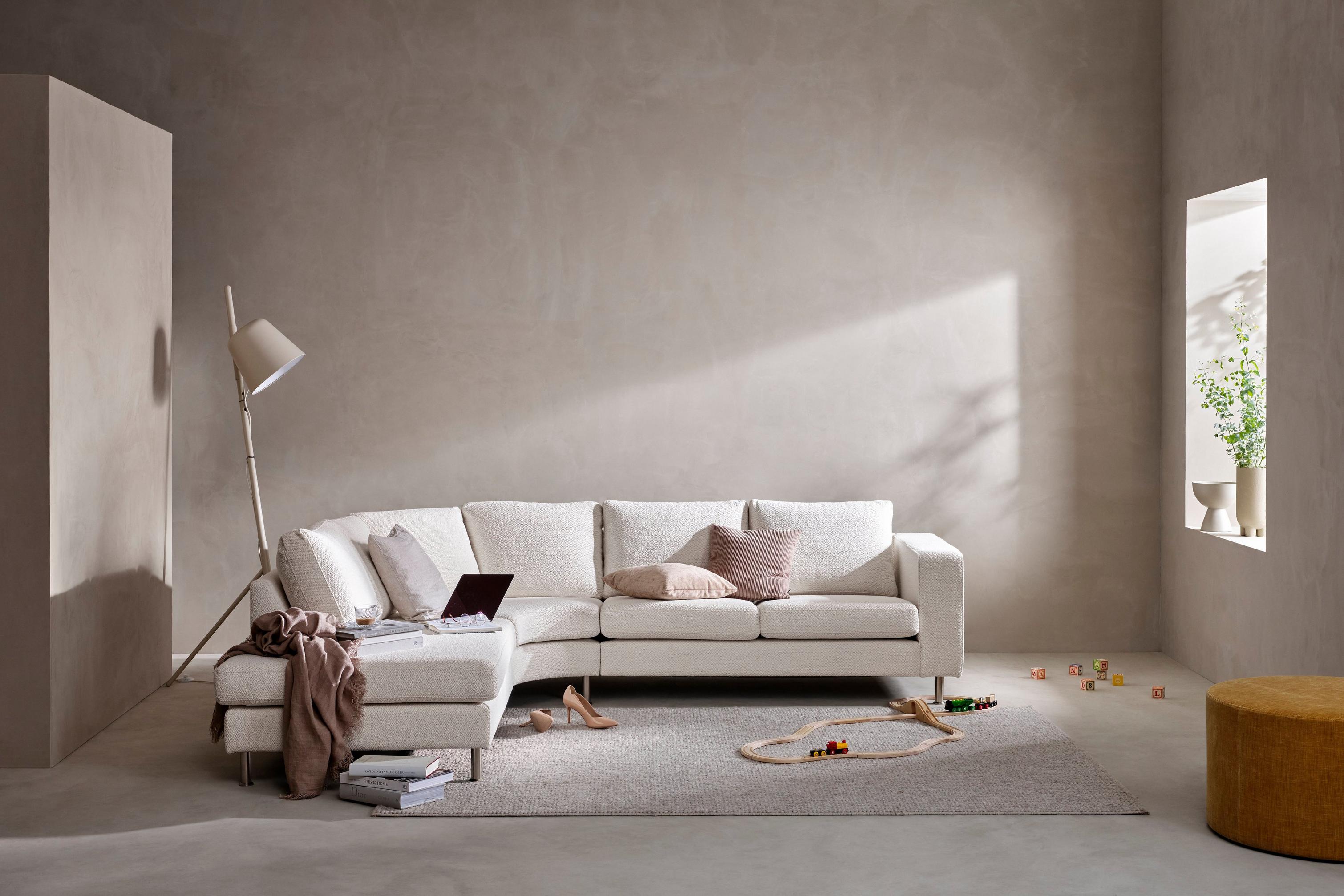 Indivi sofa placeret i lille rum præget af grå toner