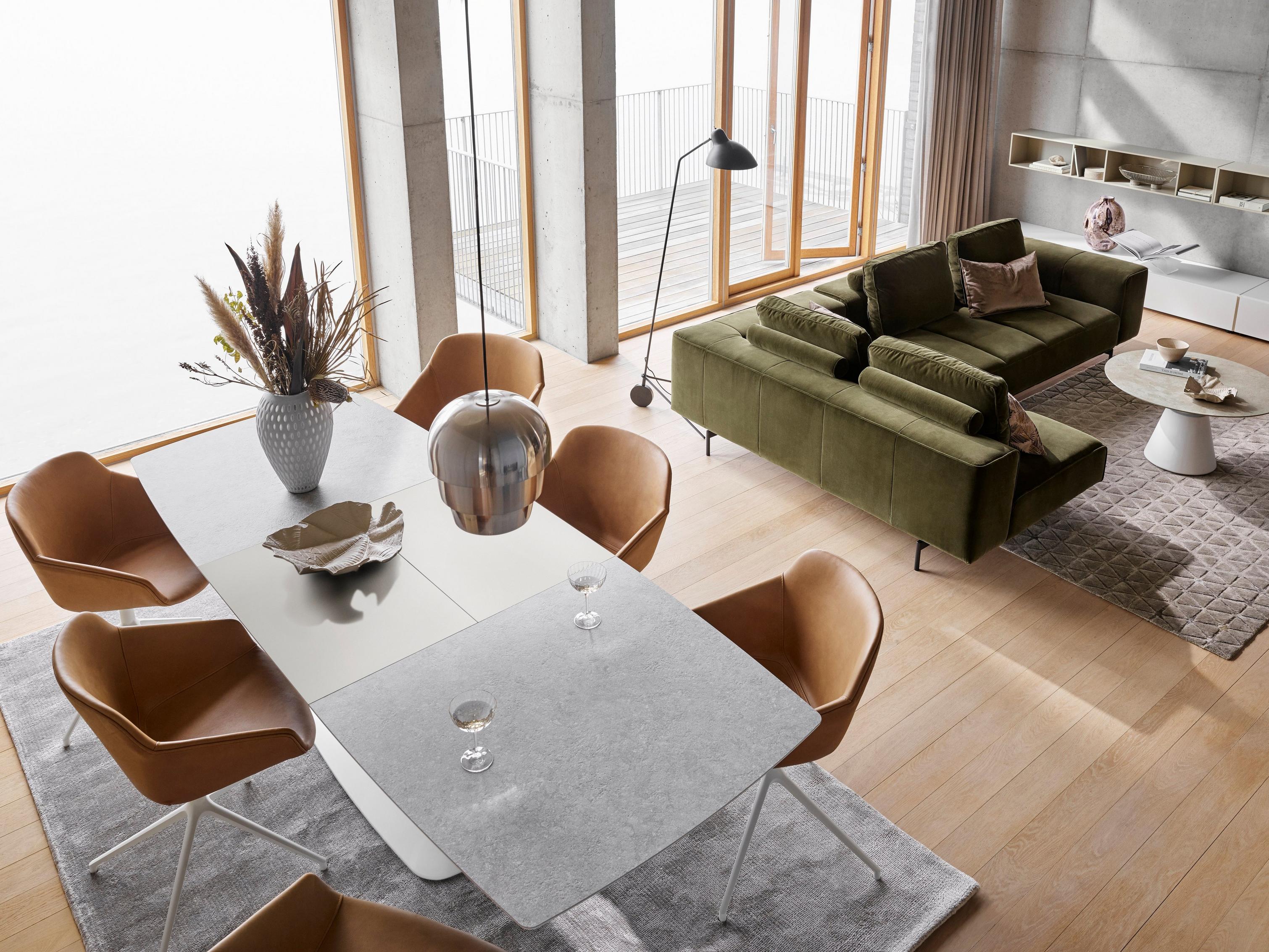 橄榄绿天鹅绒带躺卧式单元 Amsterdam 转角沙发，搭配 Alicante 餐桌、Madrid 咖啡桌和琥珀色 York 皮革面料 Vienna 椅。