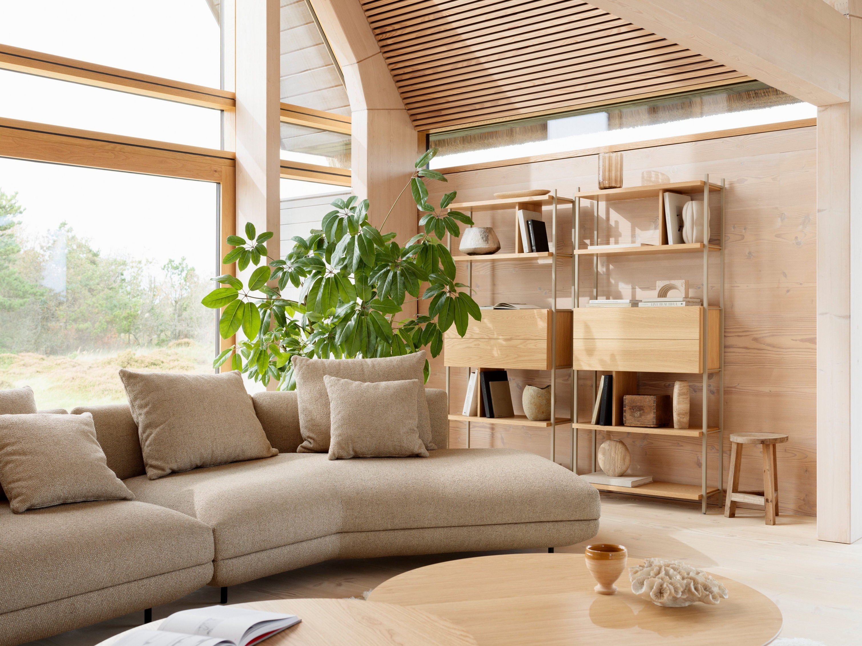 Moderna sala inspirada en la naturaleza con sofá Salamanca tapizado en tela Lazio marrón.