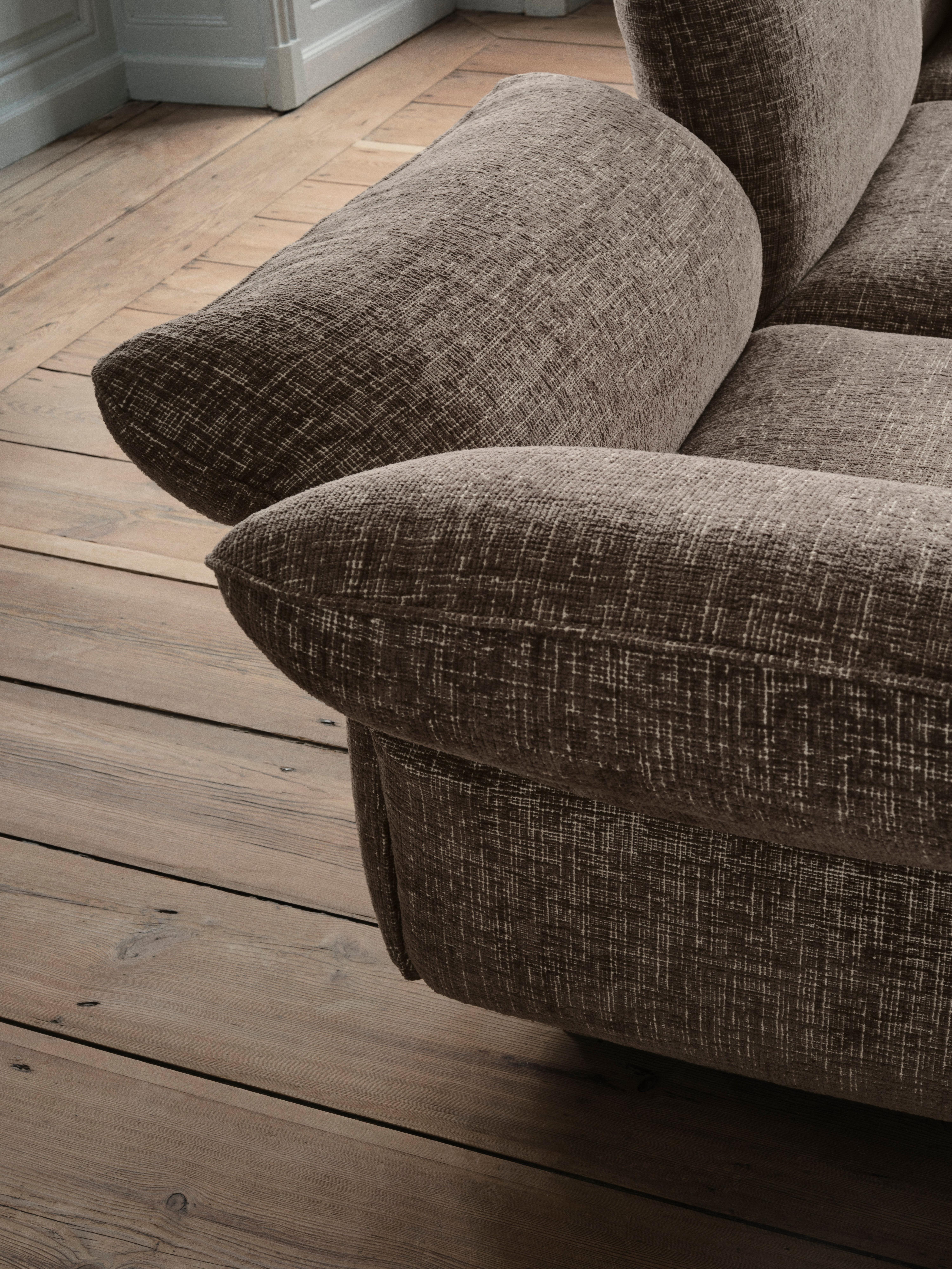 Close-up of textured fabric sofa armrest and seat cushion.