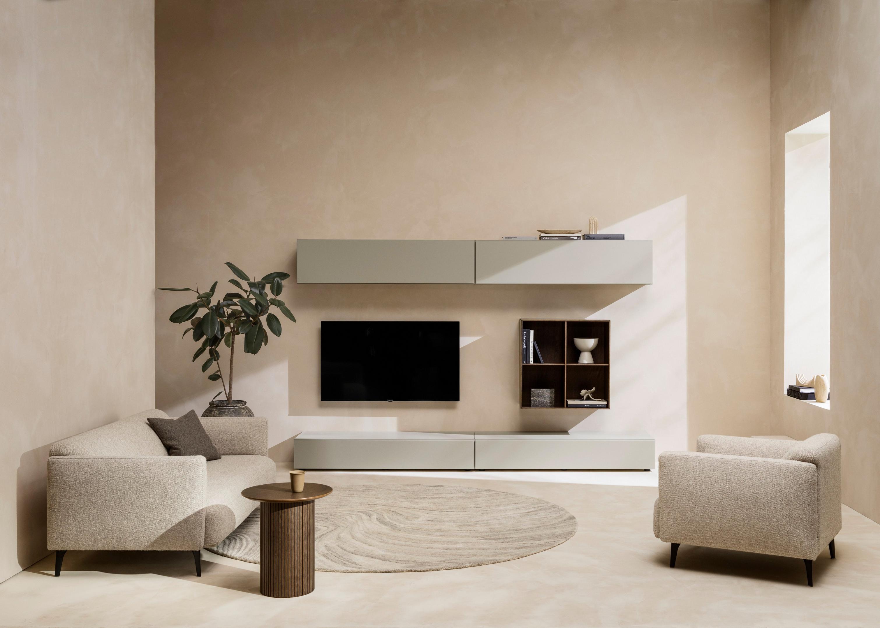 Stue indrettet i en neutral farvepalet med rundt Santiago sofabord, der indbyder til afslapning.