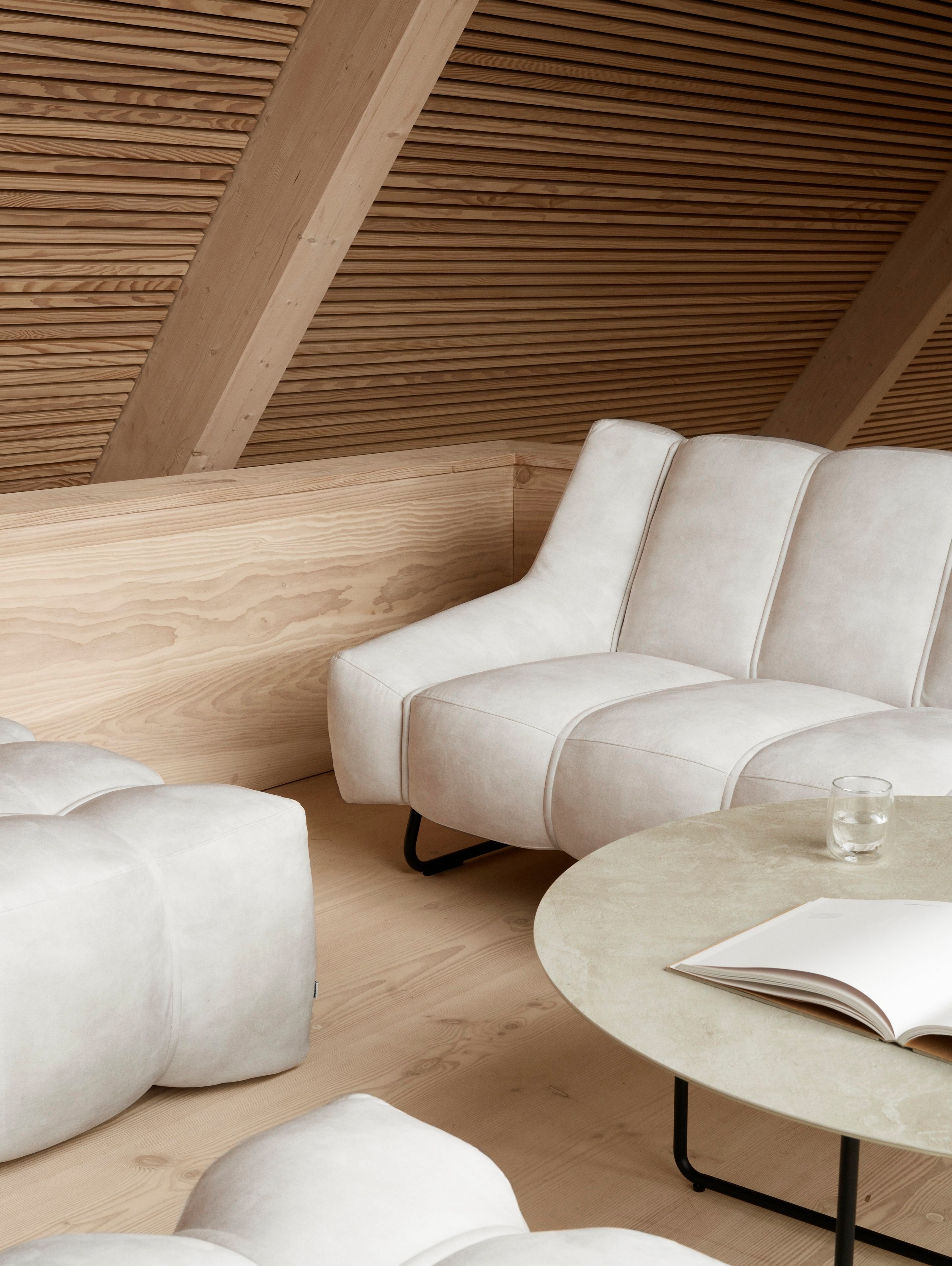 Obývačka v škandinávskom štýle so sedačkou Nawabari a zladenými taburetkami.