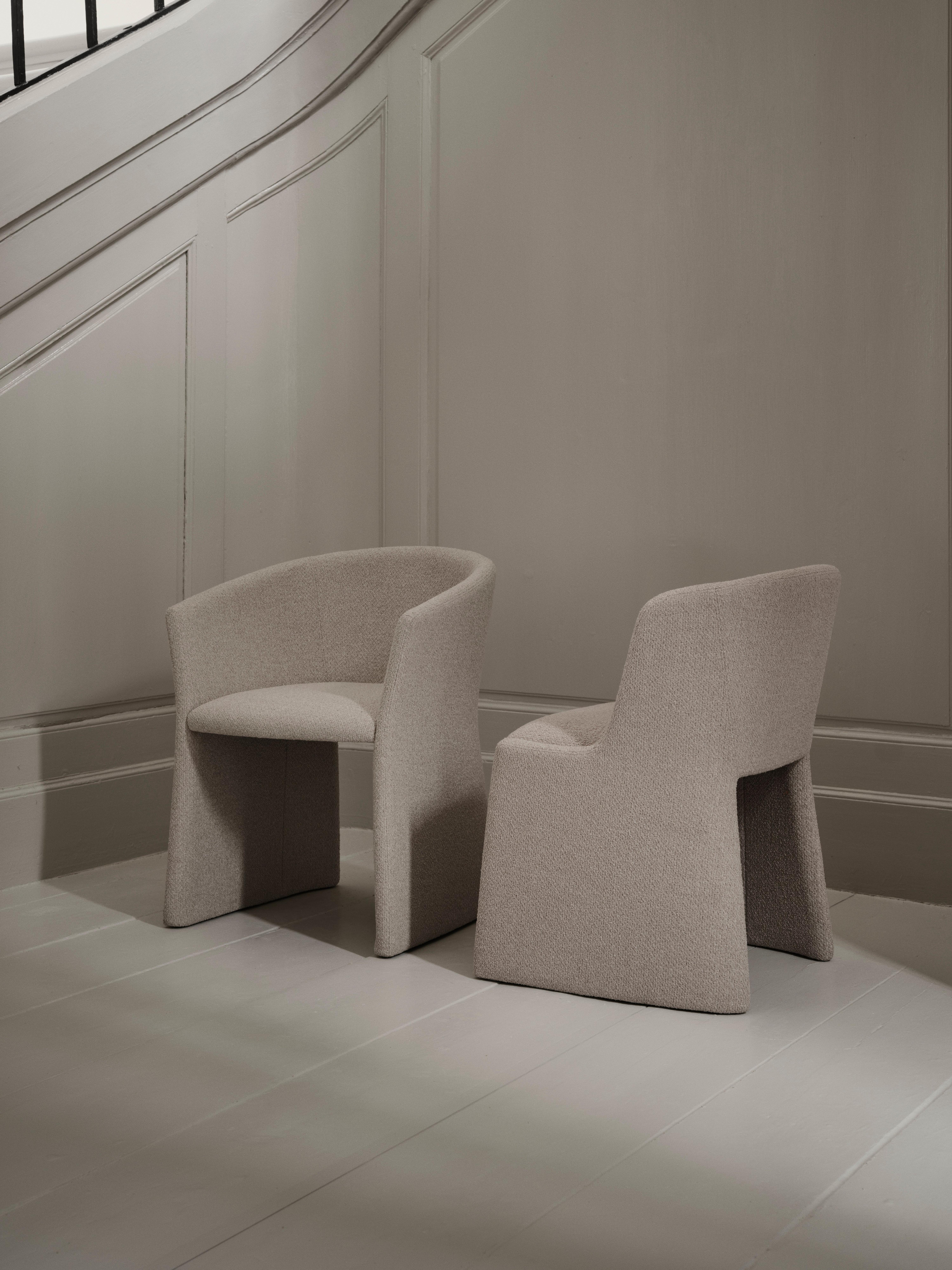 Two upholstered lounge chairs in textured fabric, shown side by side.