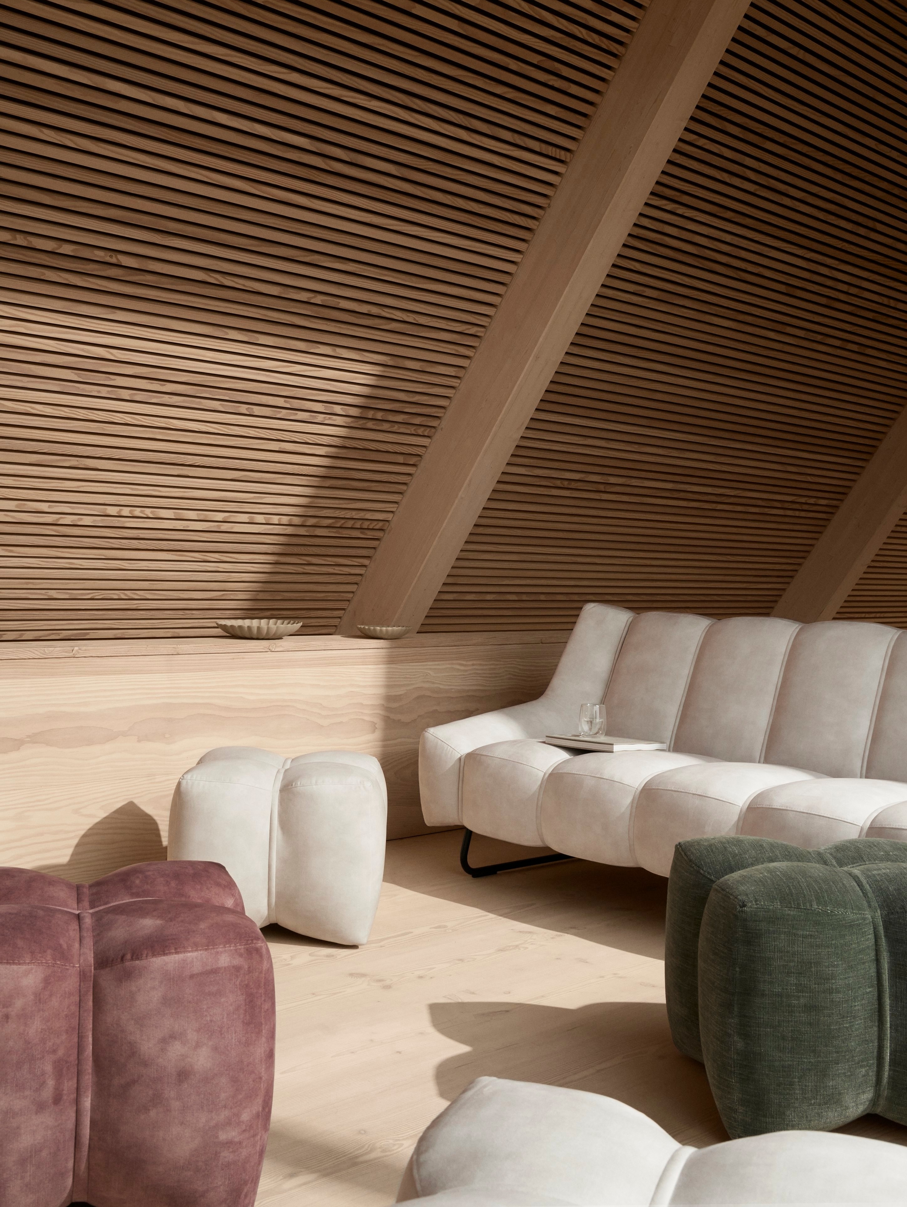 Neutralny pokój dzienny w domu typu "A-frame"  z 3-osobową sofą Nawabari tapicerowaną beżową tkaniną Ravello.