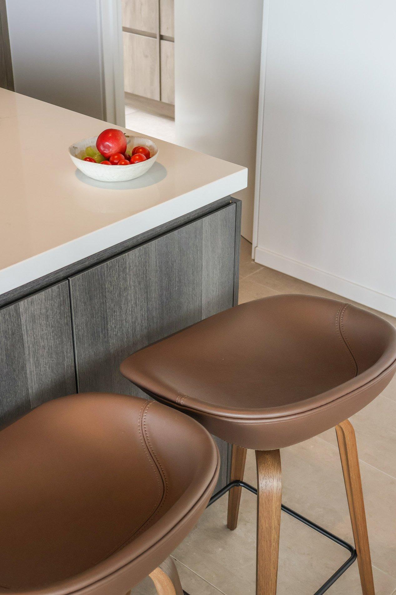 To brune barkrakker ved kjøkkenøy, skål med frukt og tomater.