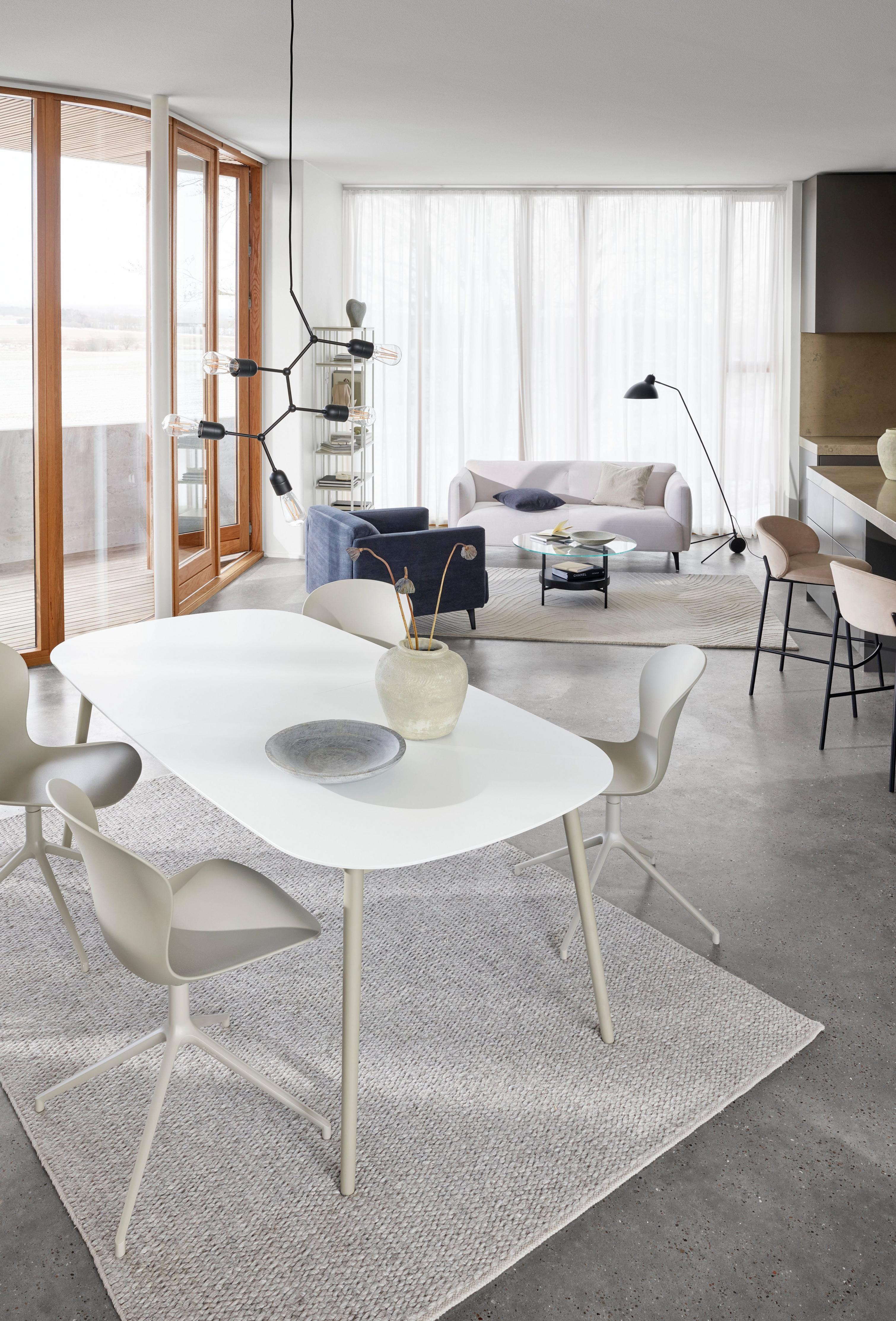 Kingston table in a matt white lacquered finish with the Princeton barstool and the Moderna 2,5 seater sofa in the background.