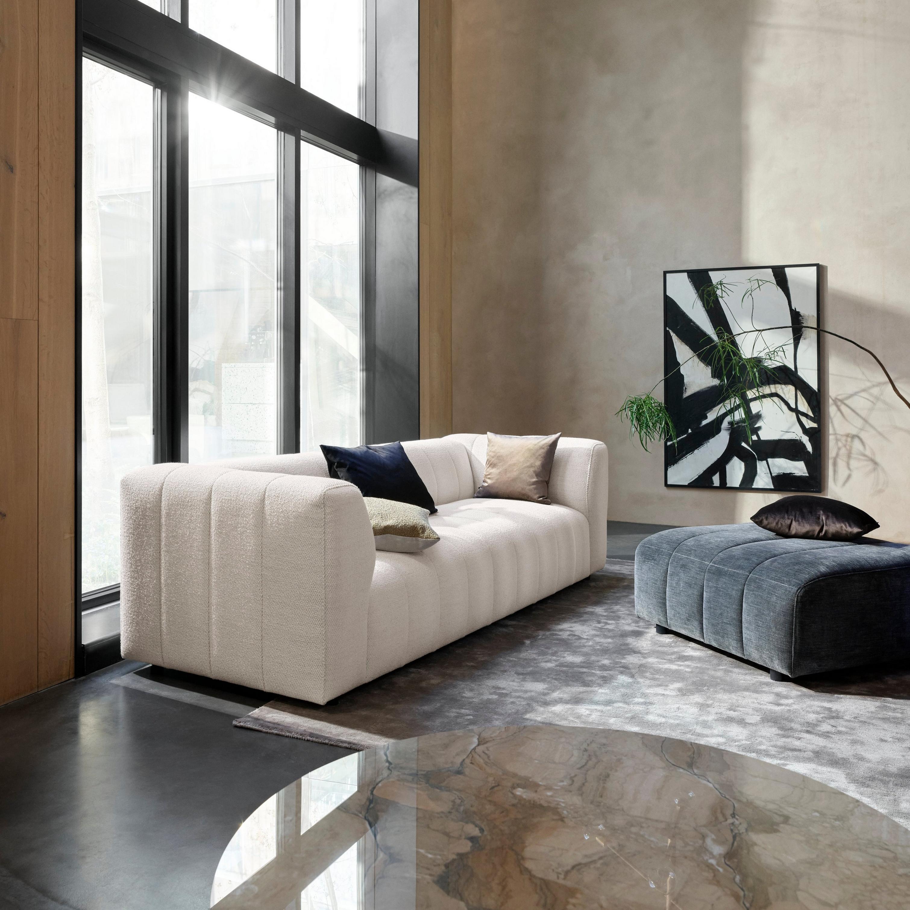 Modern living room with high ceilings, a Bellagio sofa in white Lazio fabric, a large window, and minimalist decor.