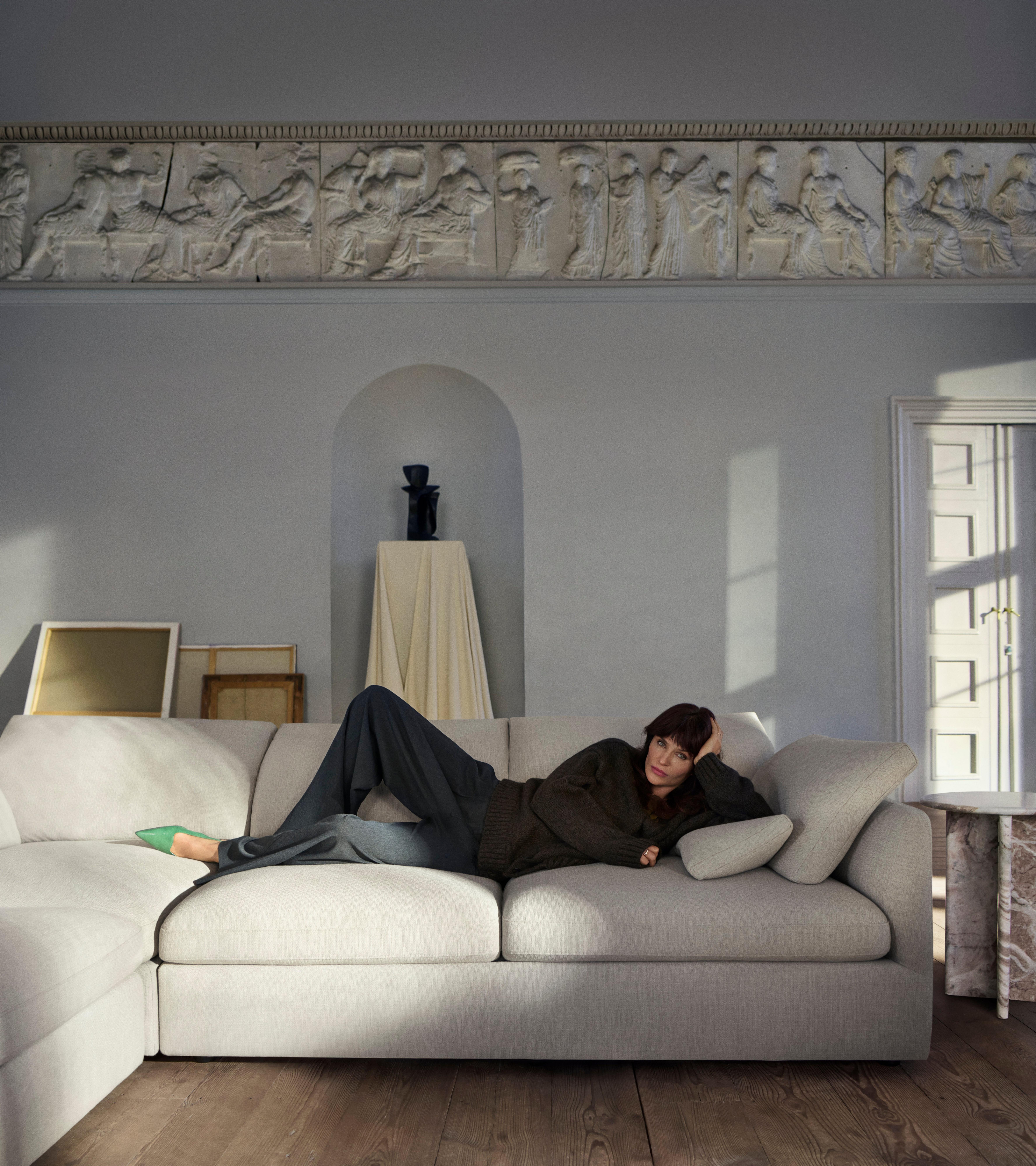 Modern dining area with a Santiago dining table, six black leather Seoul chairs, a pendant light, abstract art, a vase, and large windows.
