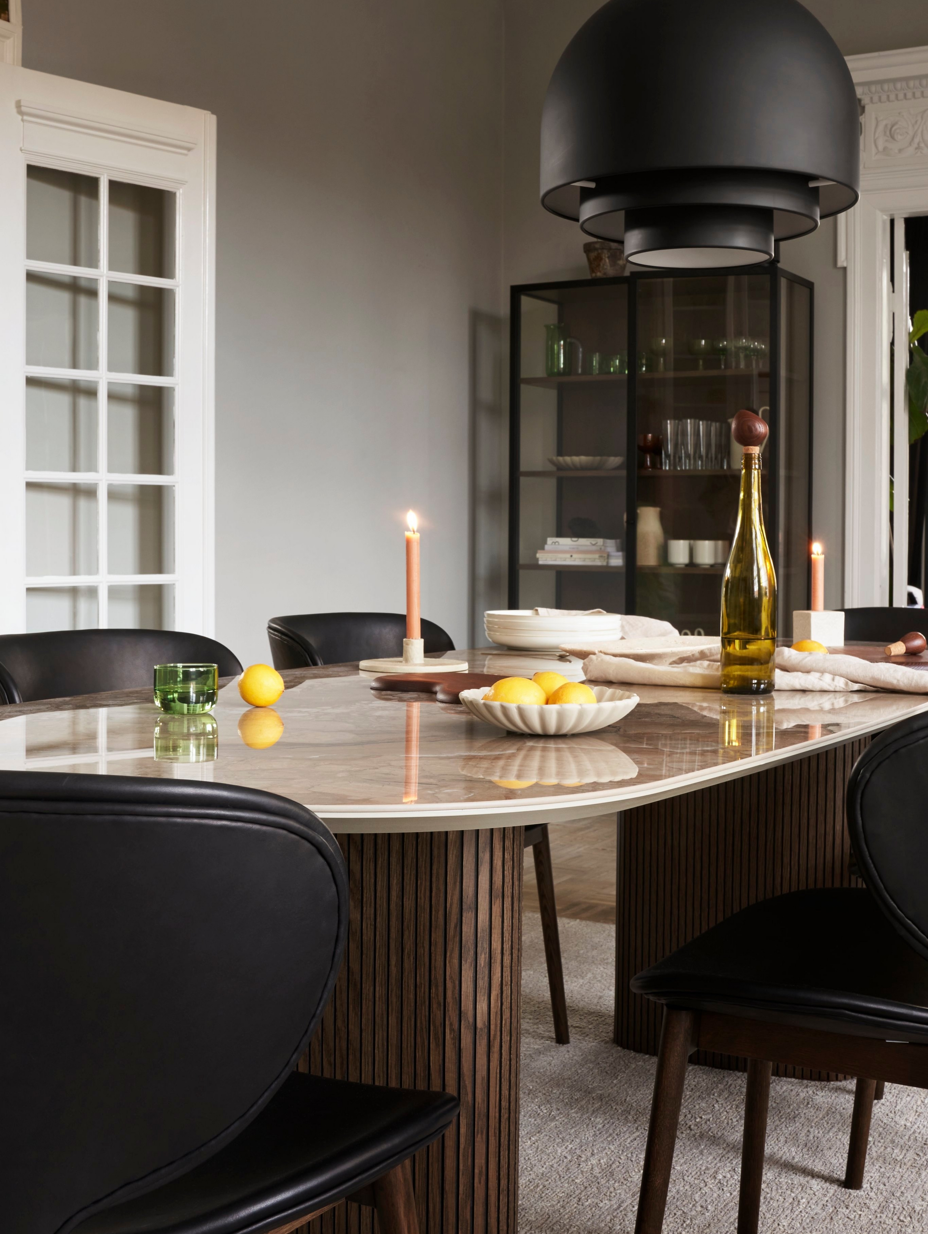 The Santiago dining table with candles, a fruit bowl, a wine bottle and more.