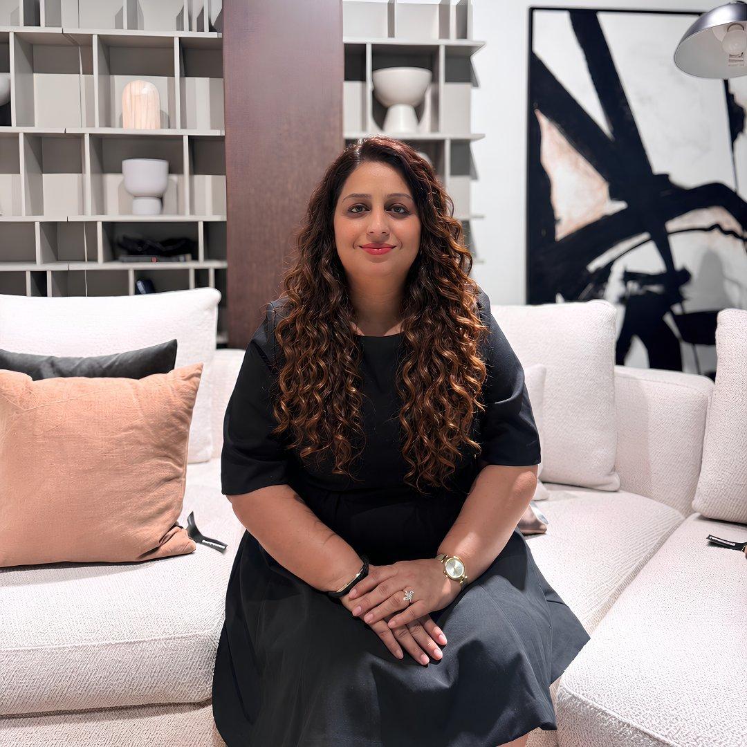 Woman sitting on a sofa in a living room setting.
