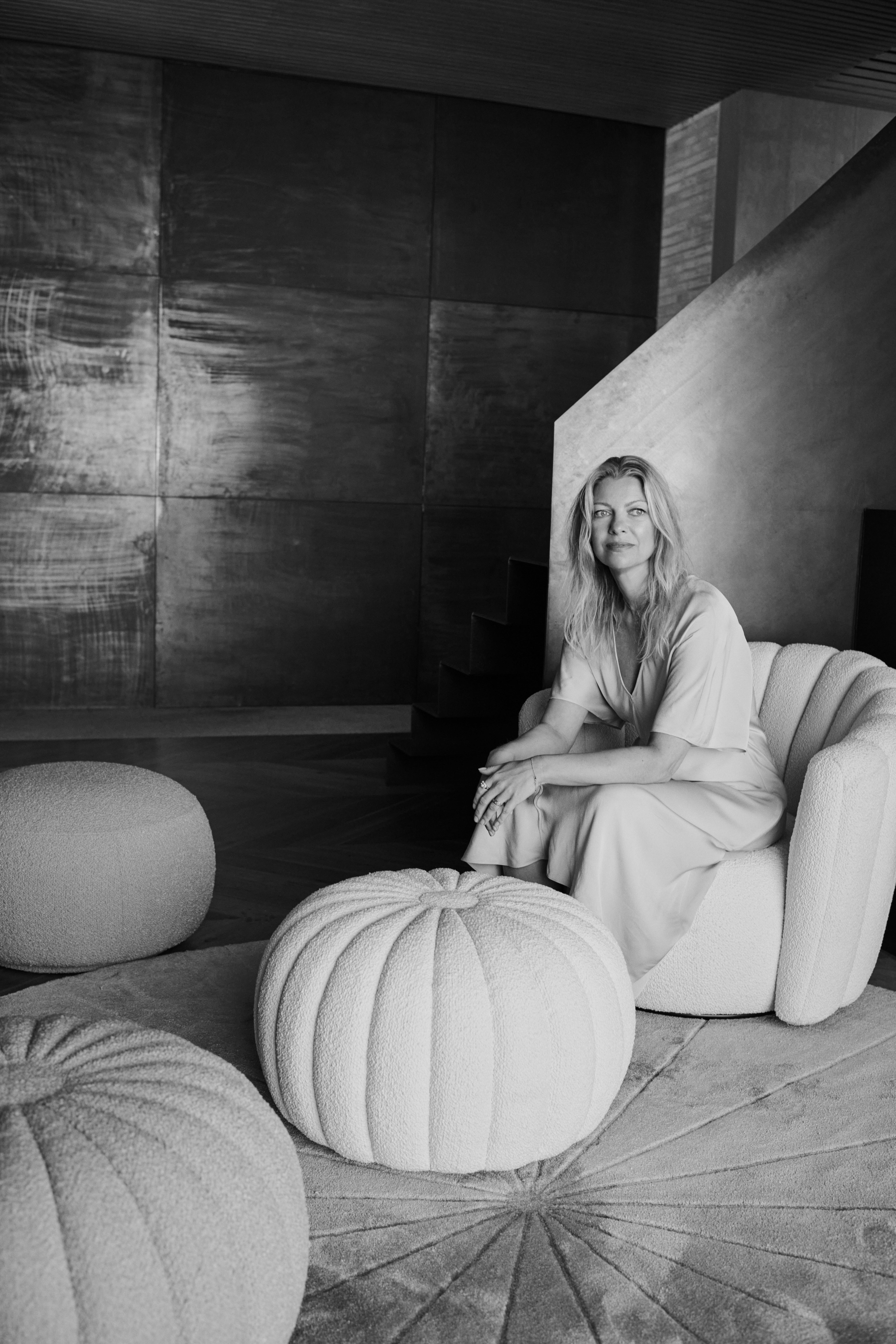 Black and white picture of designer Charlotte Høncke sitting in her Sweet Art armchair