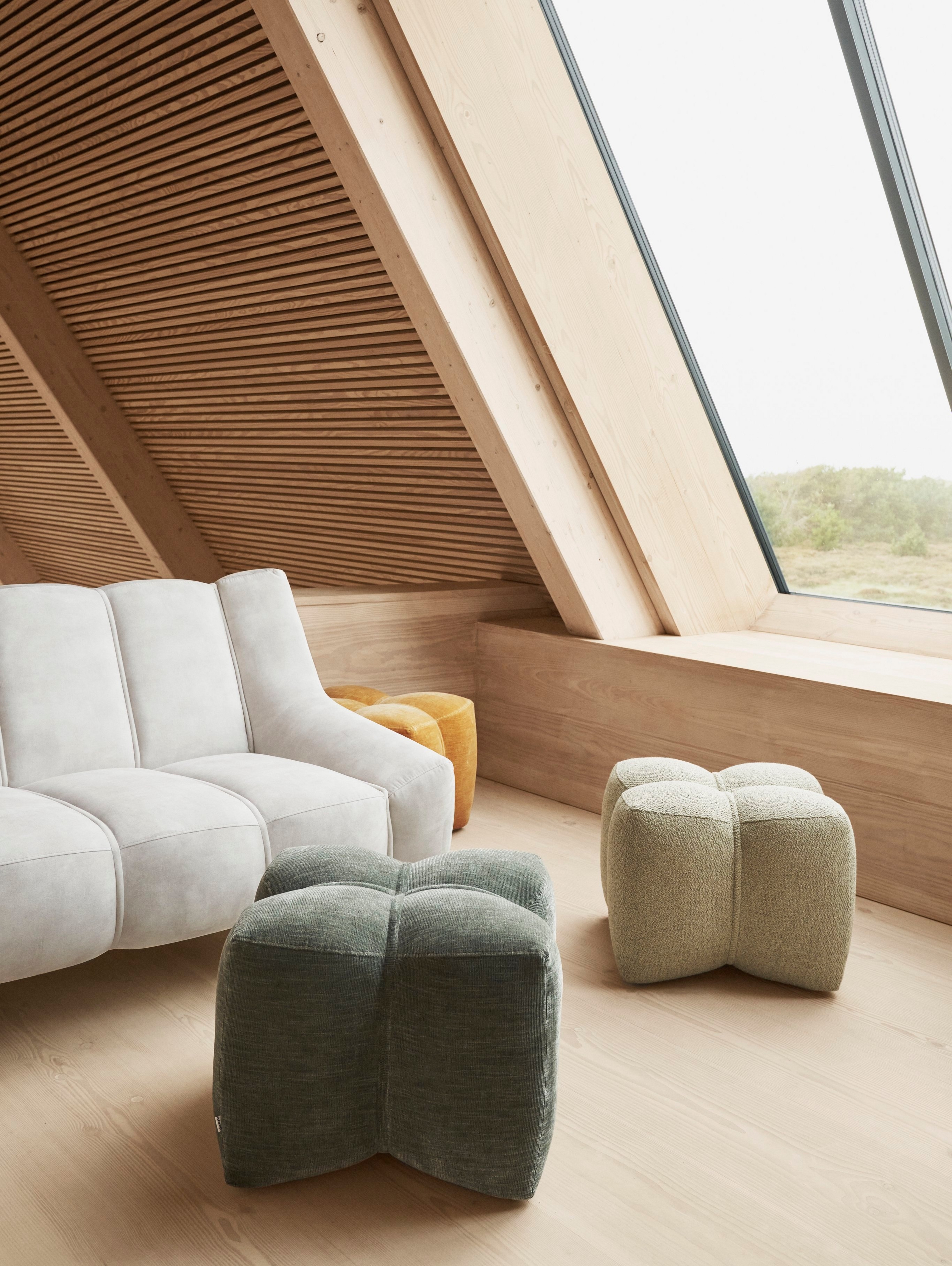 Slnečný obývací priestor so sedačkou Nawabari a zladenými taburetkami.